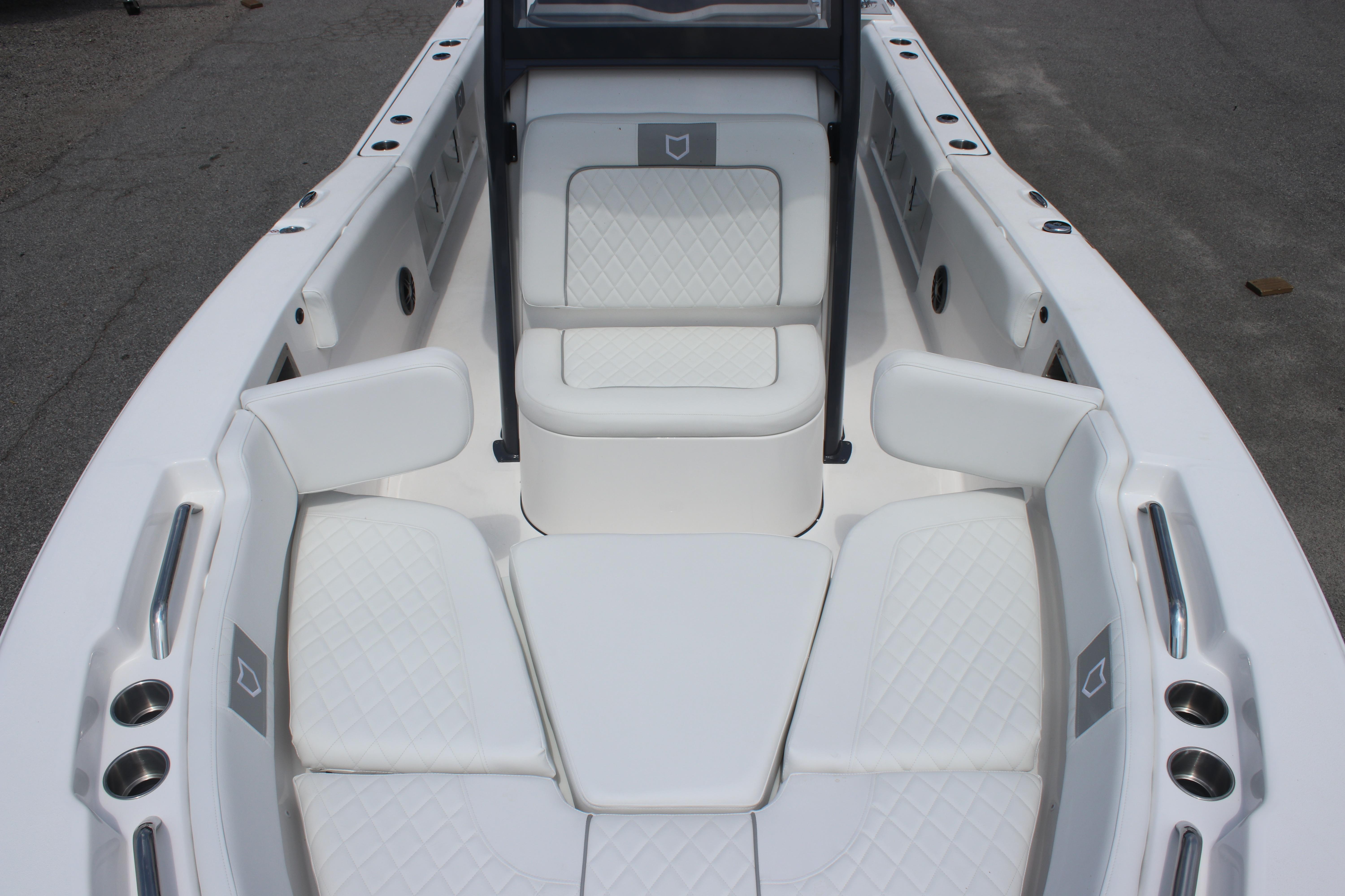 2026 Sea Fox 248 Commander boat interior with white cushioned seating and cup holders.