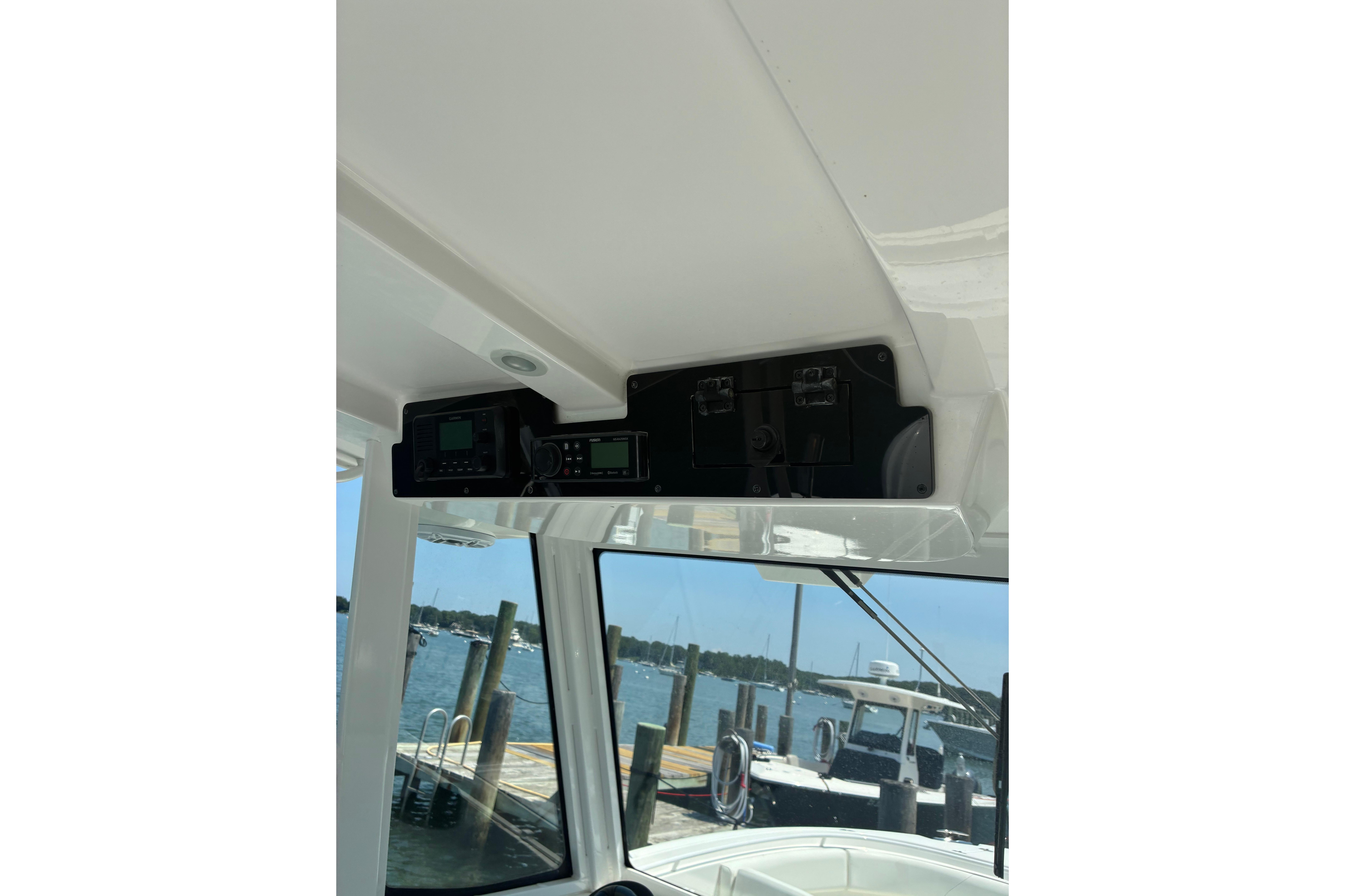 2023 Edgewater 285CC boat dashboard with electronic controls, docked at marina.