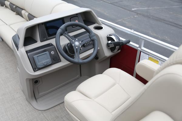 Interior view of a Sun Tracker Party Barge 24 DLX boat with beige steering wheel and seats.