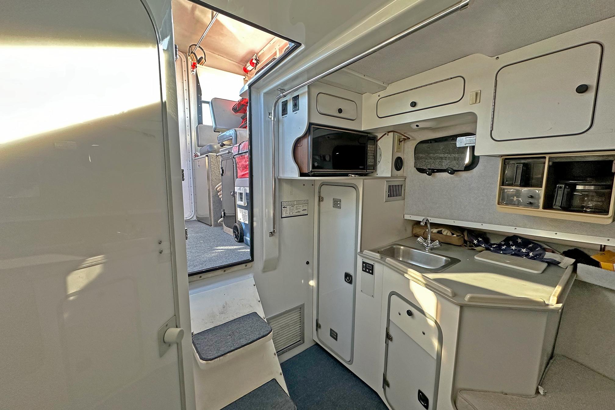 Interior of a 1990 Boston Whaler 36 Defiance boat, featuring a compact kitchenette.