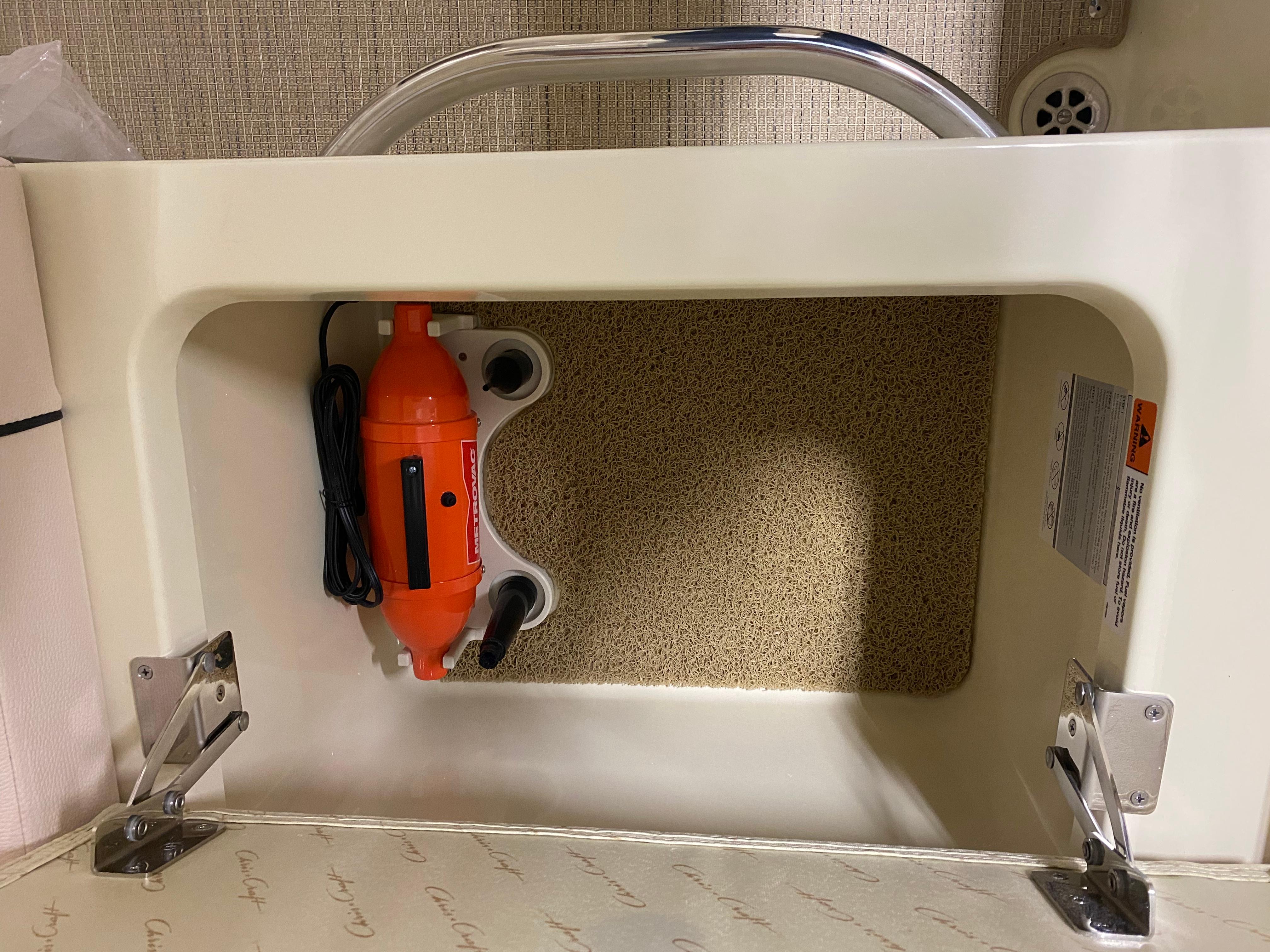 Storage compartment in 2025 Chris-Craft Launch 28 GT boat with orange device inside.