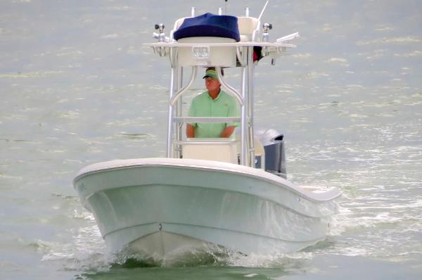 A 2011 Andros 26 Tarpon boat on the water. A person is standing at the helm.