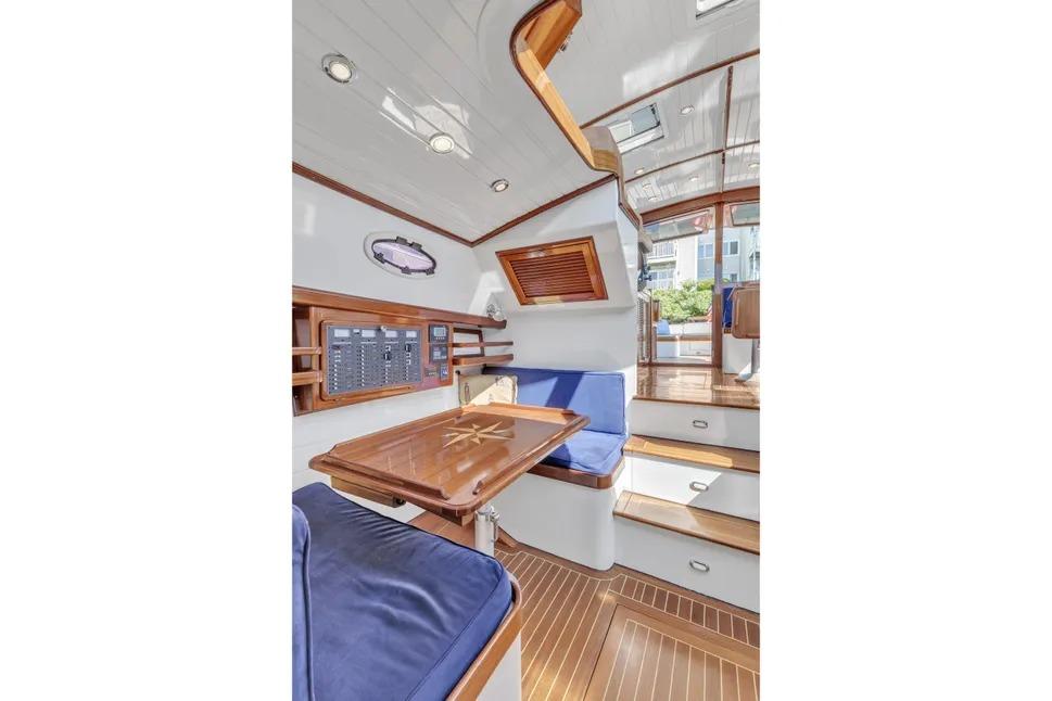 Interior of 2007 Gorbon Custom Downeast 40 yacht with wooden finishes and blue seating.