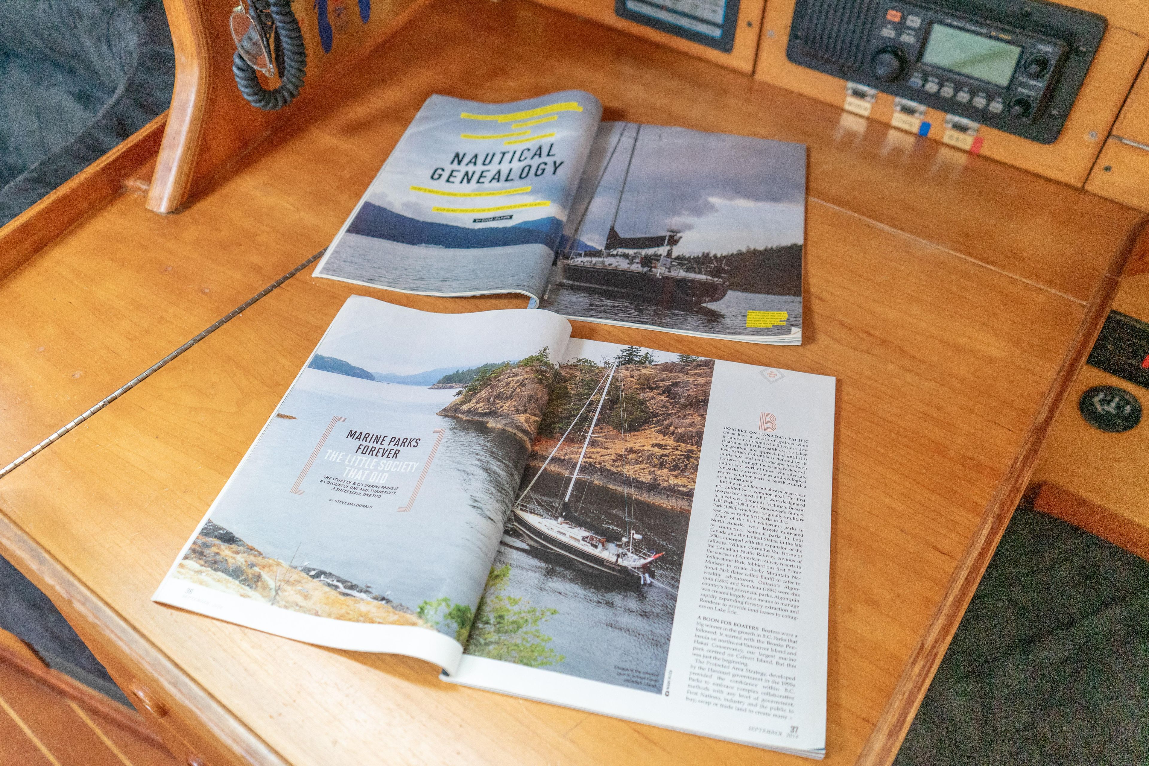 Open magazines on a wooden table inside a 1997 Sabre 402 sailboat cabin.