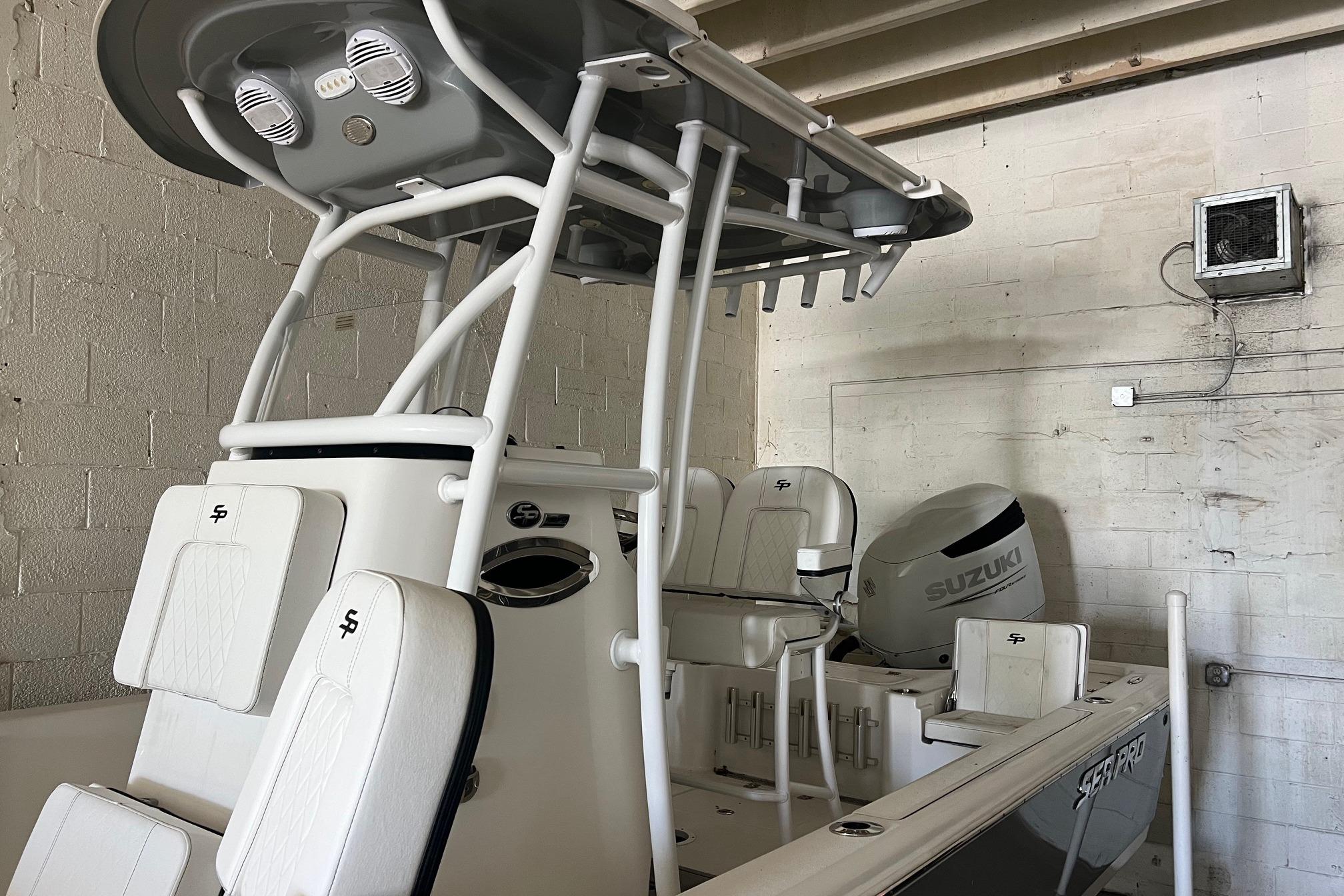 2024 Sea Pro 230 Bay boat with Suzuki engine in a garage setting.