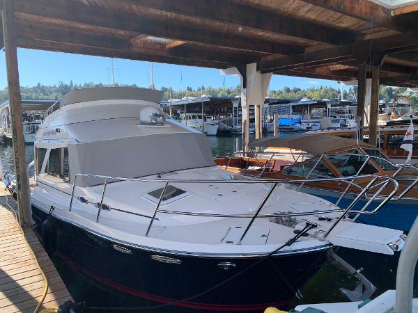 2021 Cutwater C-32 CB boat docked in a marina under a wooden shelter.
