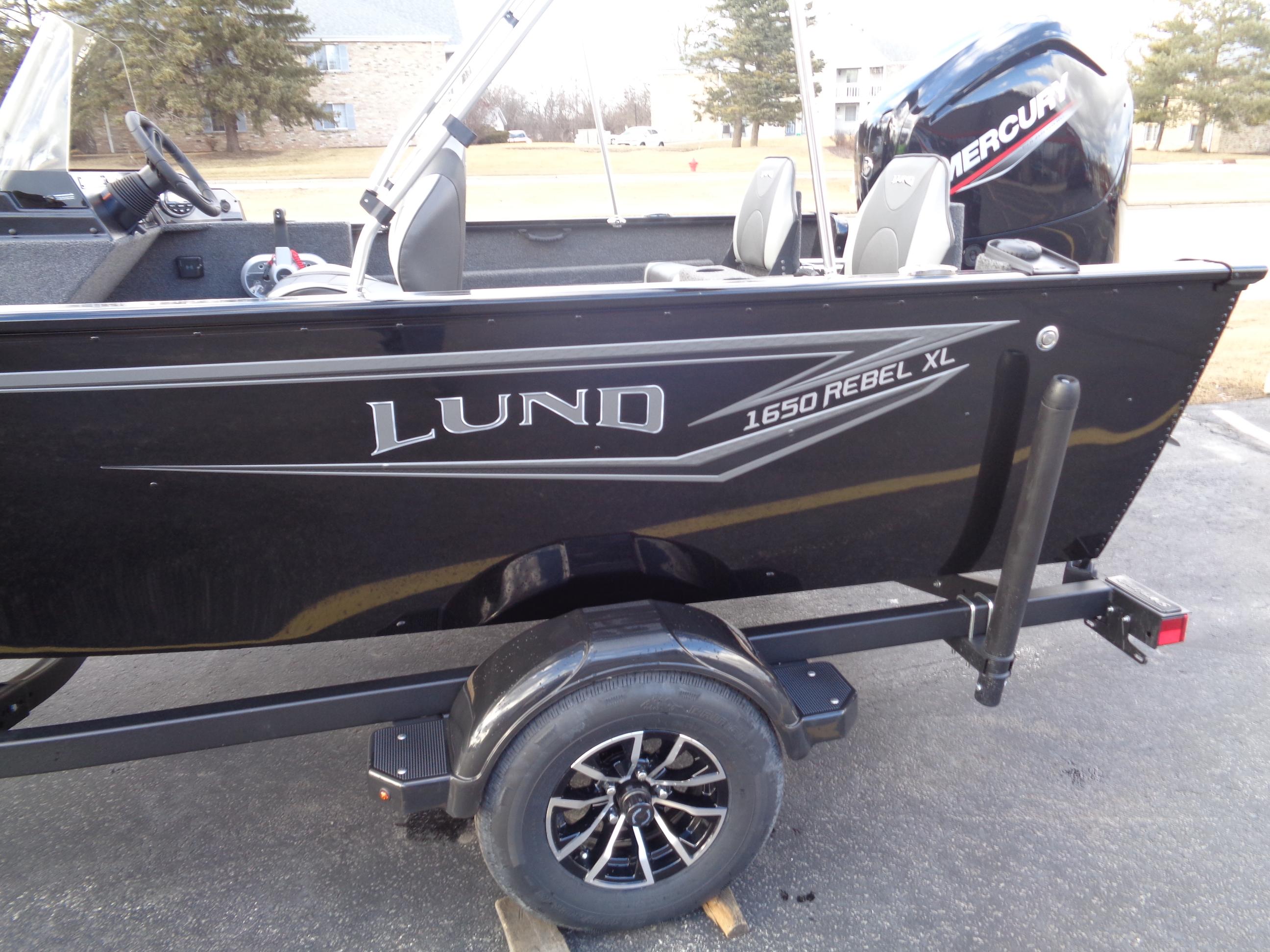 2025 Lund 1650 Rebel XL SS boat on trailer, featuring sleek black design and Mercury outboard motor.