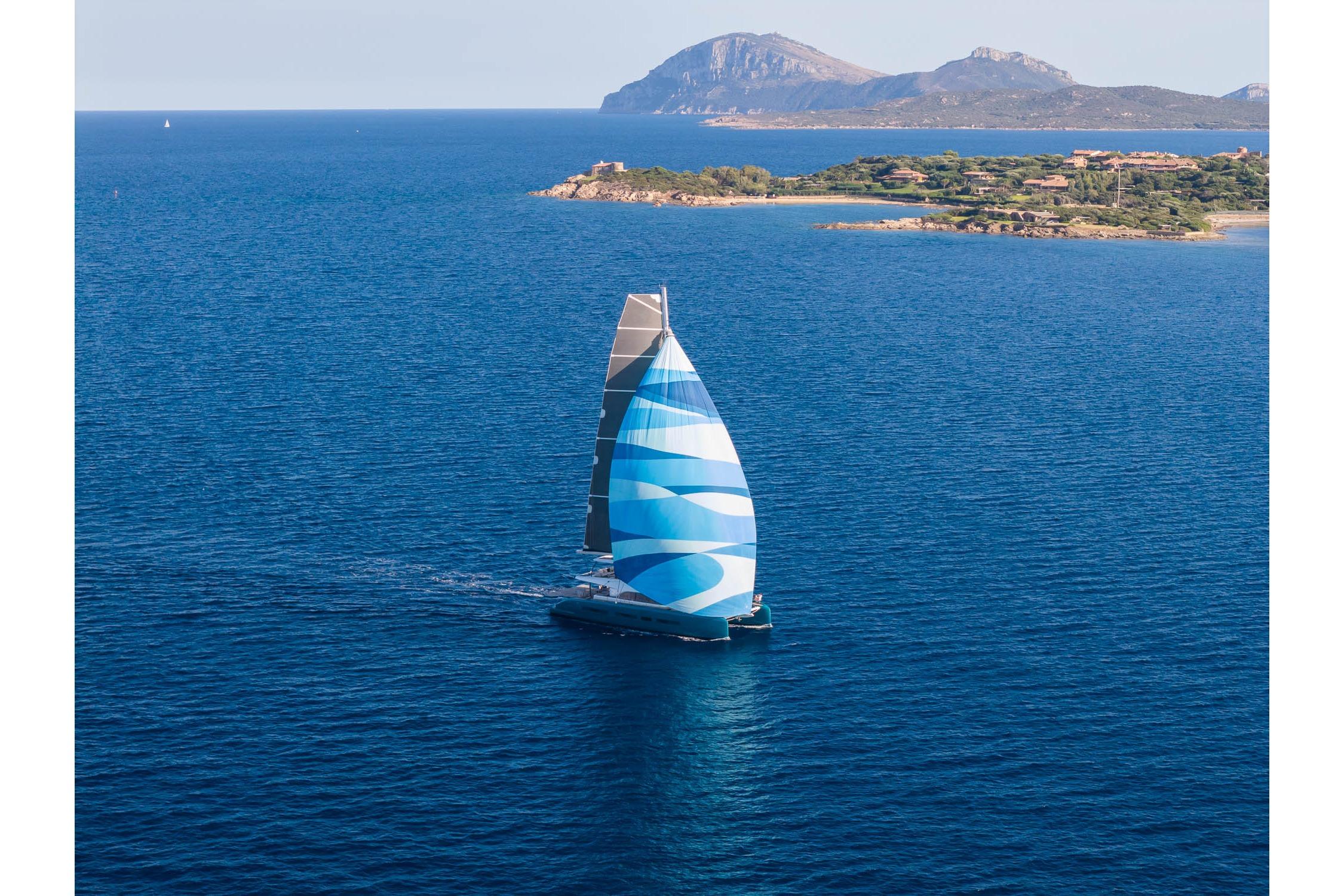Sailing yacht Lagoon Eighty 2, 2026 model, cruising near scenic coastline.