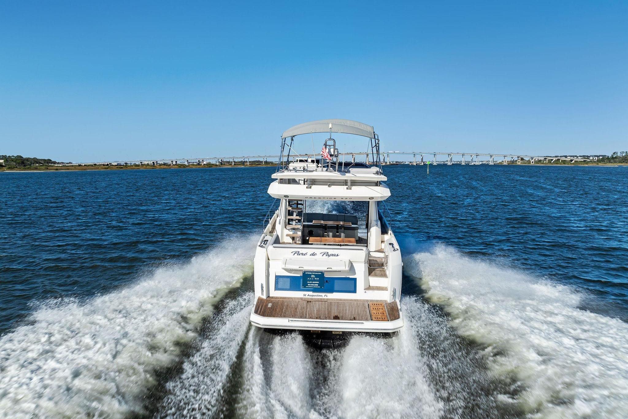 2019 Prestige 520 yacht cruising on open water under clear blue sky.