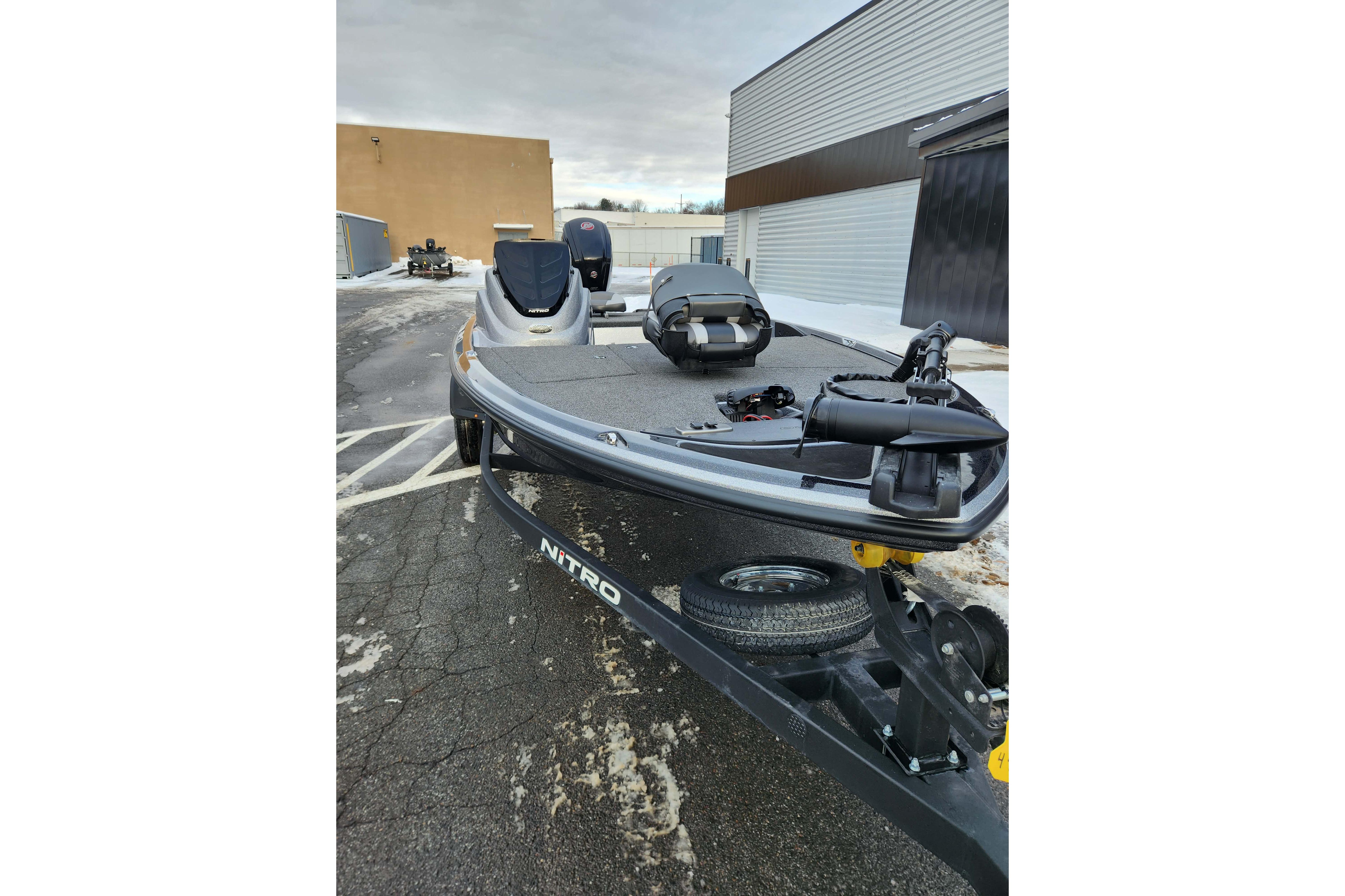 2026 Nitro Z17 boat on trailer, parked outdoors near industrial buildings.