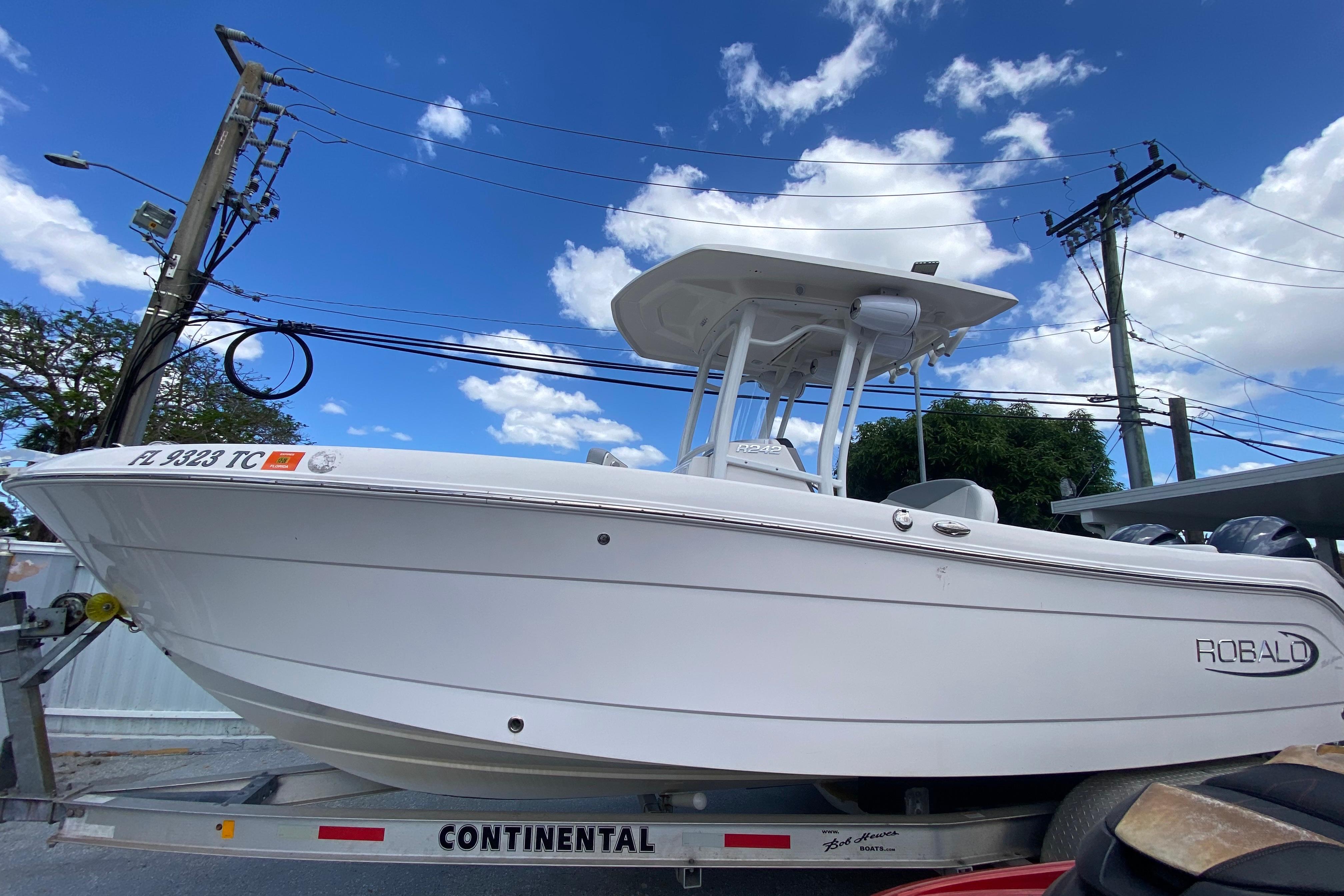 2022 Robalo R242 Center Console boat on trailer under blue sky.