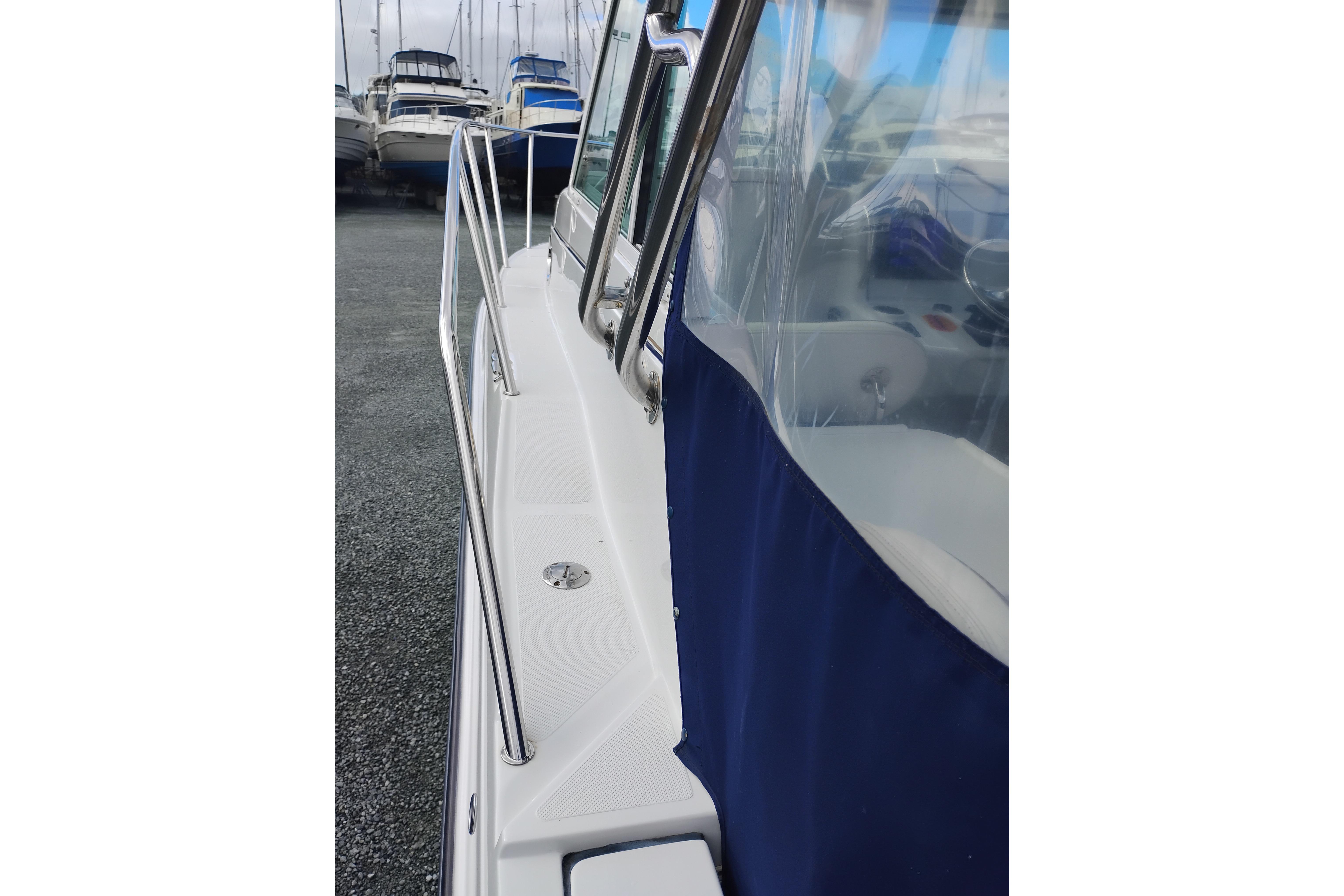 2007 Glacier Bay 2685 Coastal Runner boat with blue canopy and stainless steel railings.