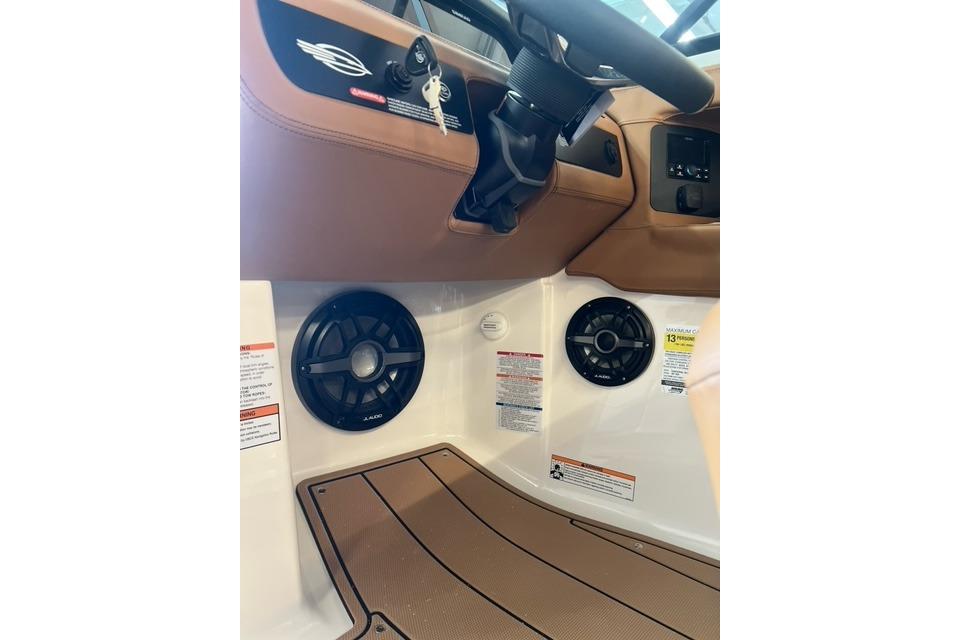 Interior view of 2025 Chaparral 247 SSX boat, featuring steering wheel and speaker system.