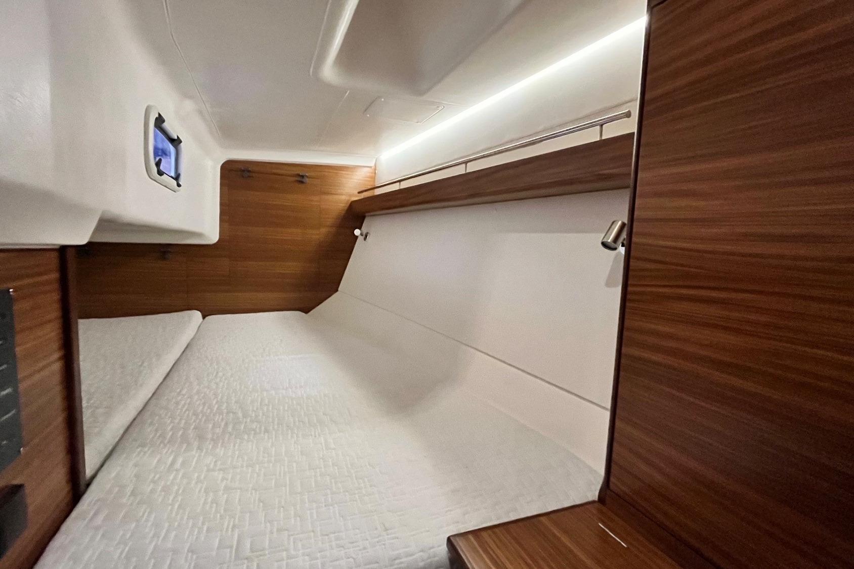 Cozy cabin interior of 2019 Sunbeam 30.2 yacht with wooden accents and bedding.