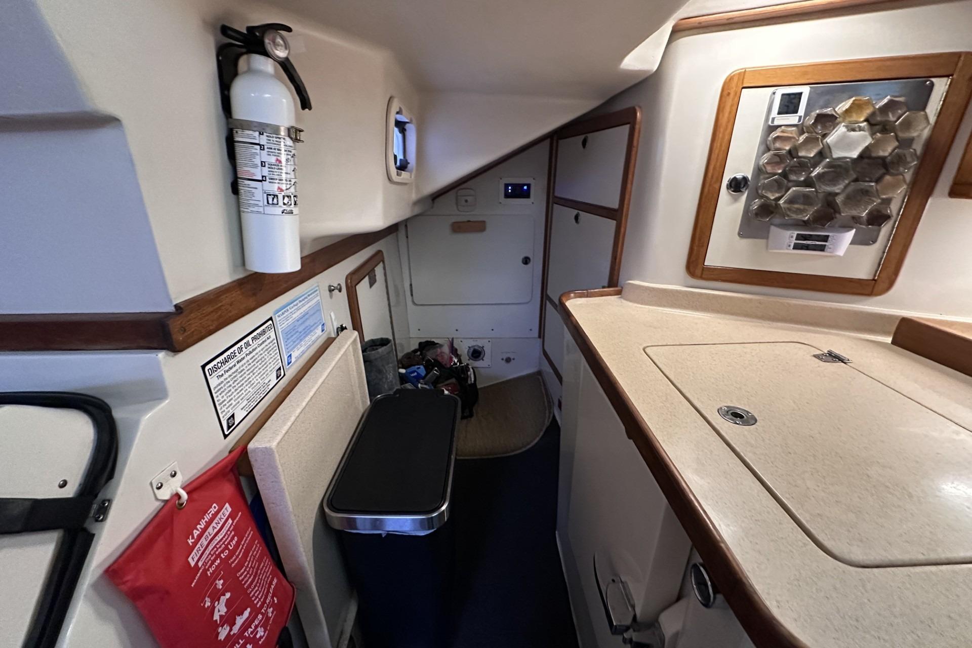 Interior of a 1999 Catalina 42 MkII sailboat, featuring a compact galley and safety equipment.