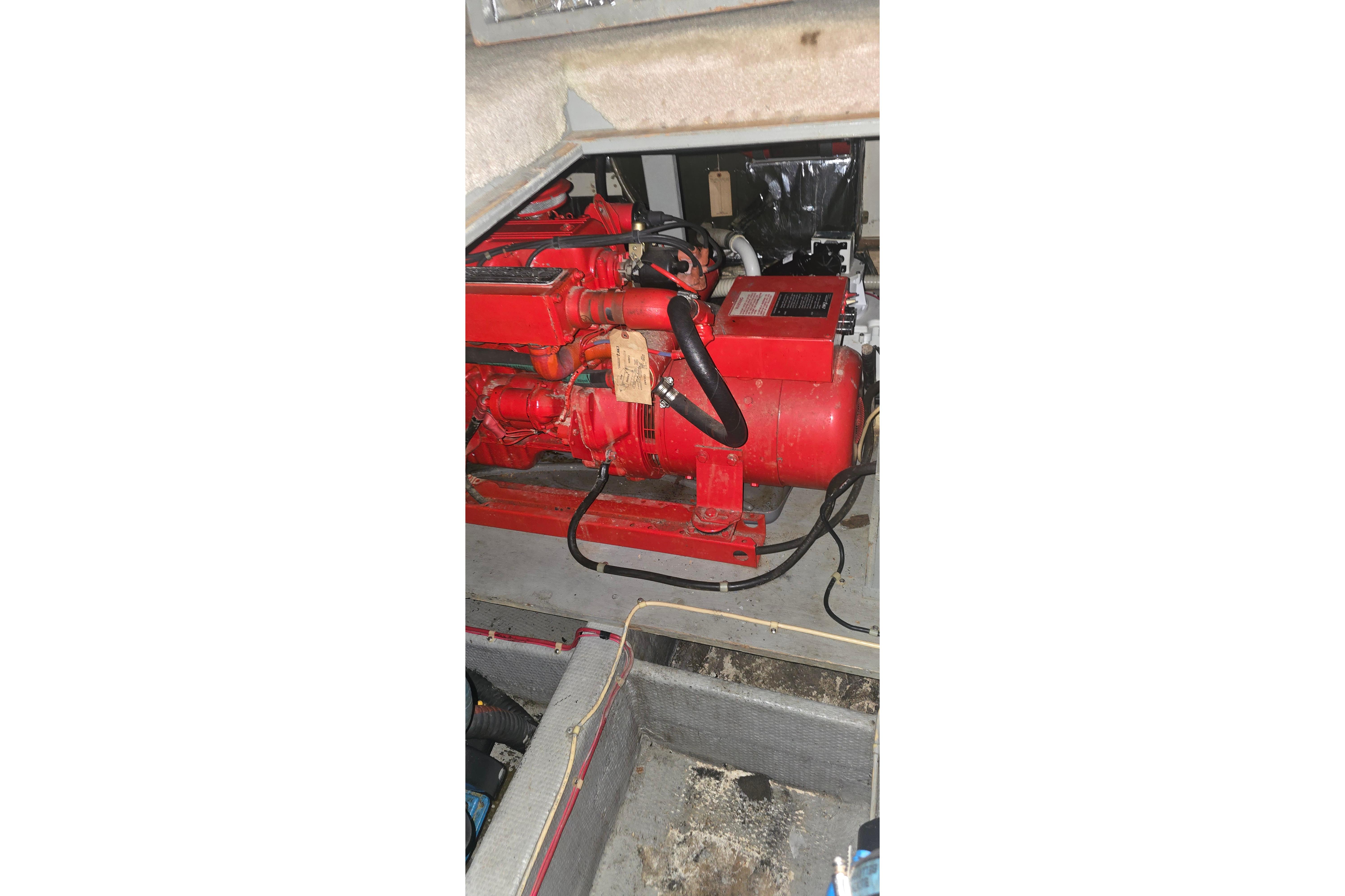 Engine compartment of 1986 Tollycraft 34 Sundeck with red machinery components.
