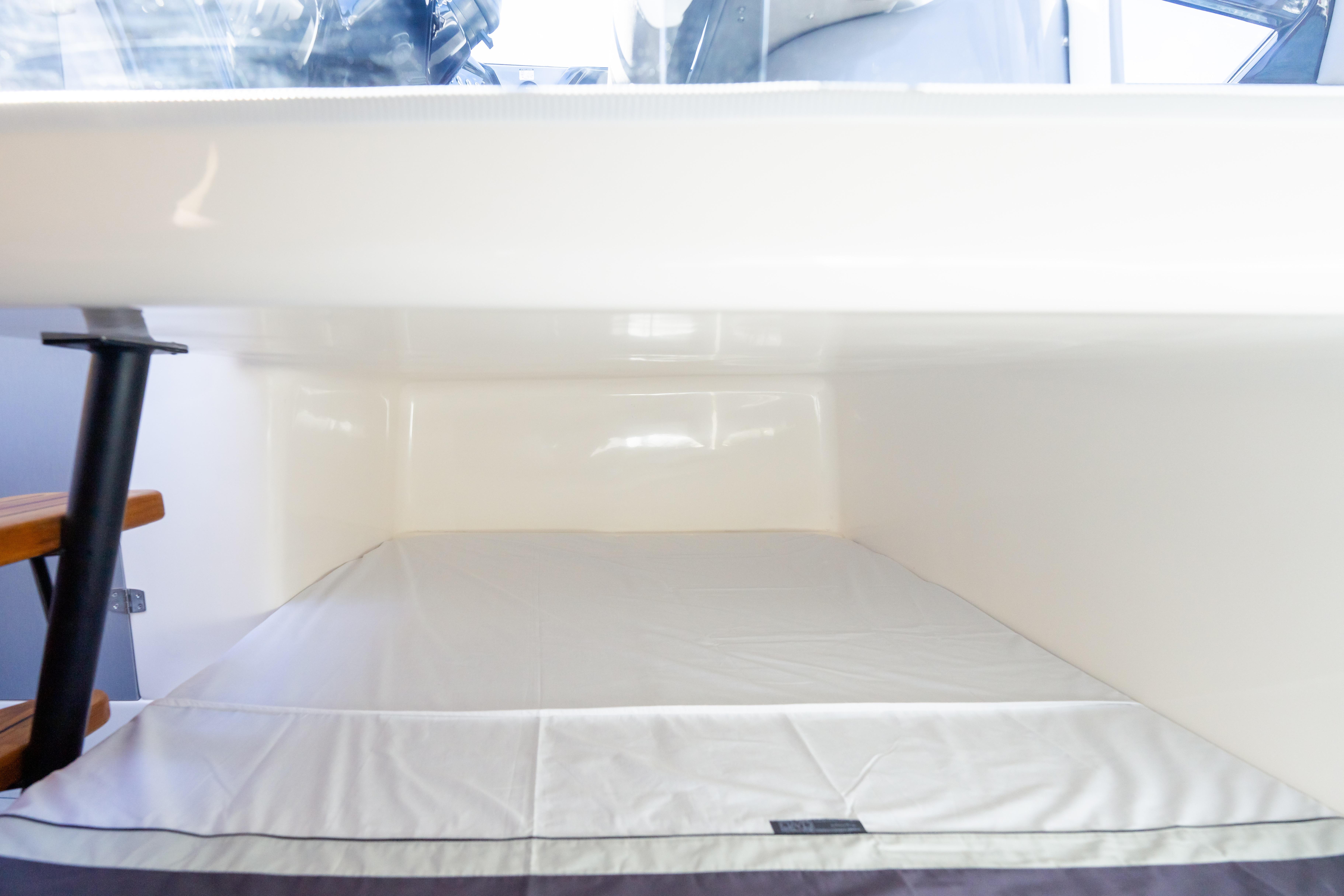 Interior cabin of 2026 Hanover 305 boat with a neatly made bed.