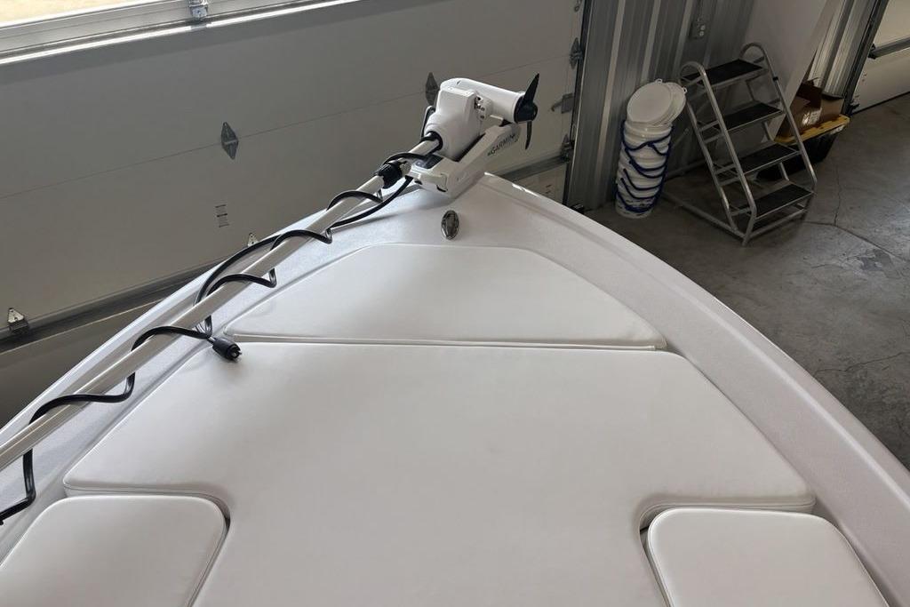 2026 Sportsman Masters 247 Bay Boat bow with trolling motor in garage setting.