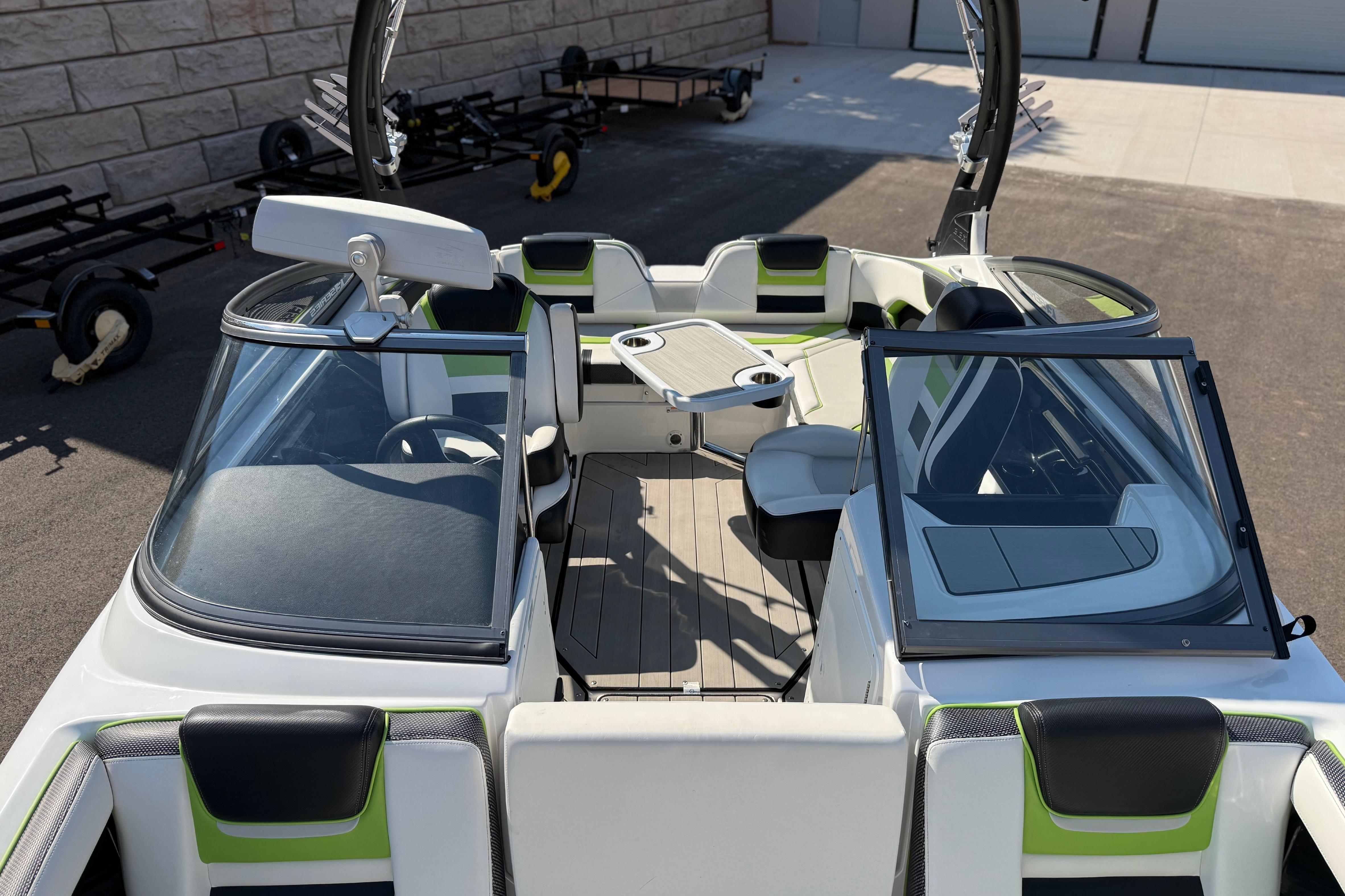2022 Yamaha Boats 212XE interior with seating and table, docked on pavement.
