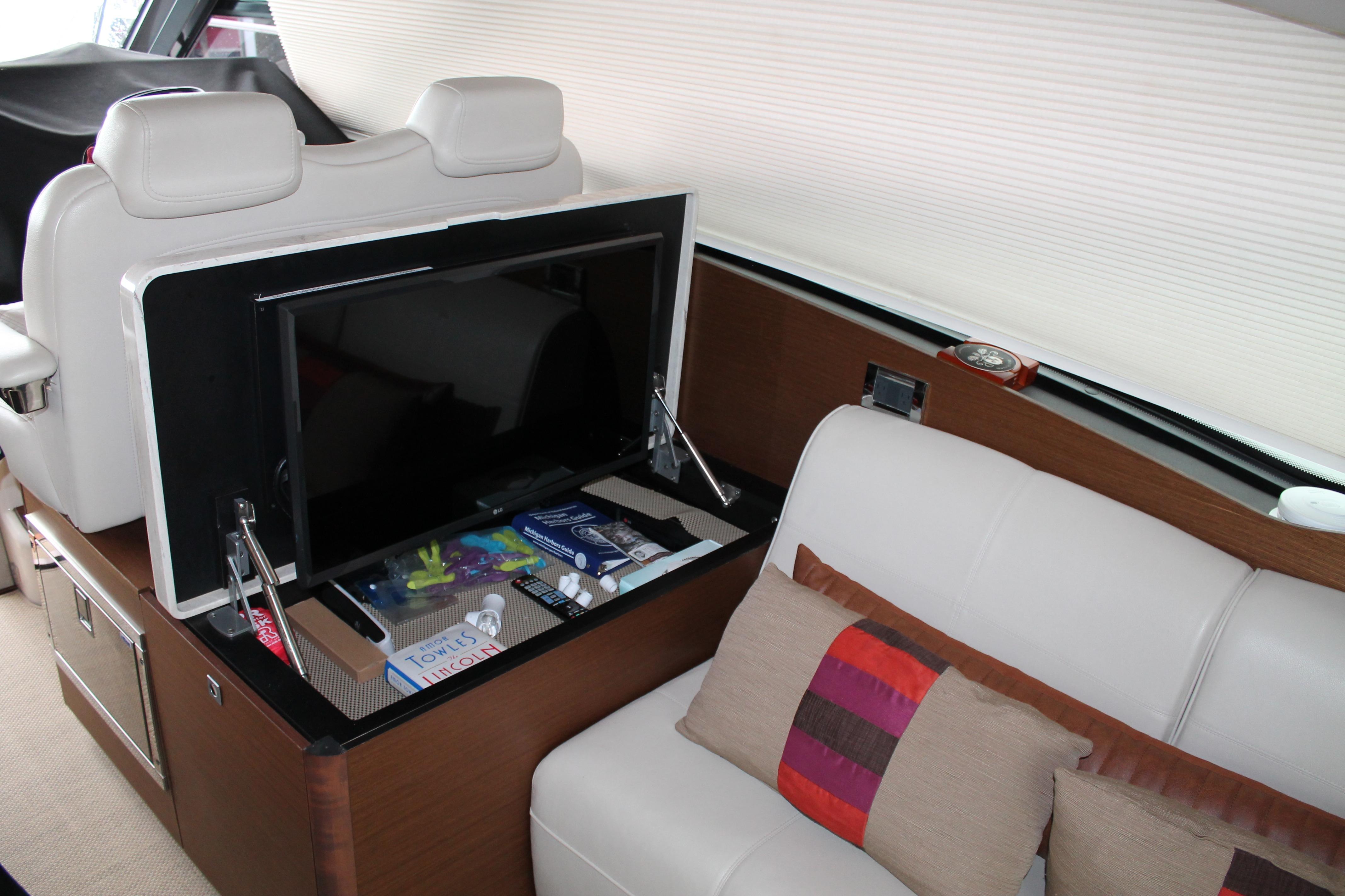 Luxurious interior of 2015 Sea Ray 470 Sundancer yacht with TV and plush seating.