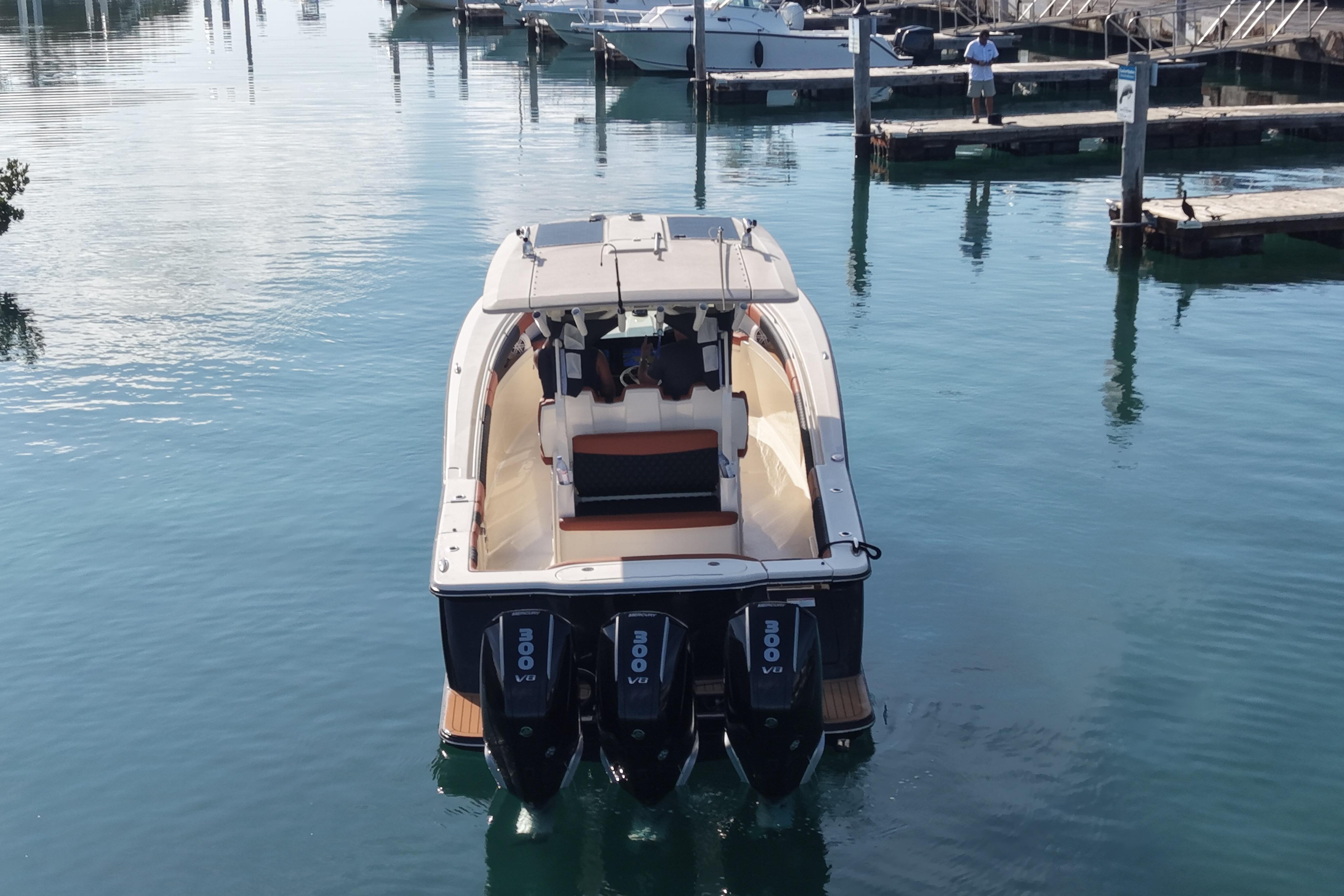 2019 Scout 355 LXF boat with triple engines docked in a marina.