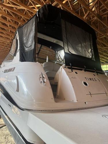 2005 Four Winns 298 Vista boat with black canopy in storage.
