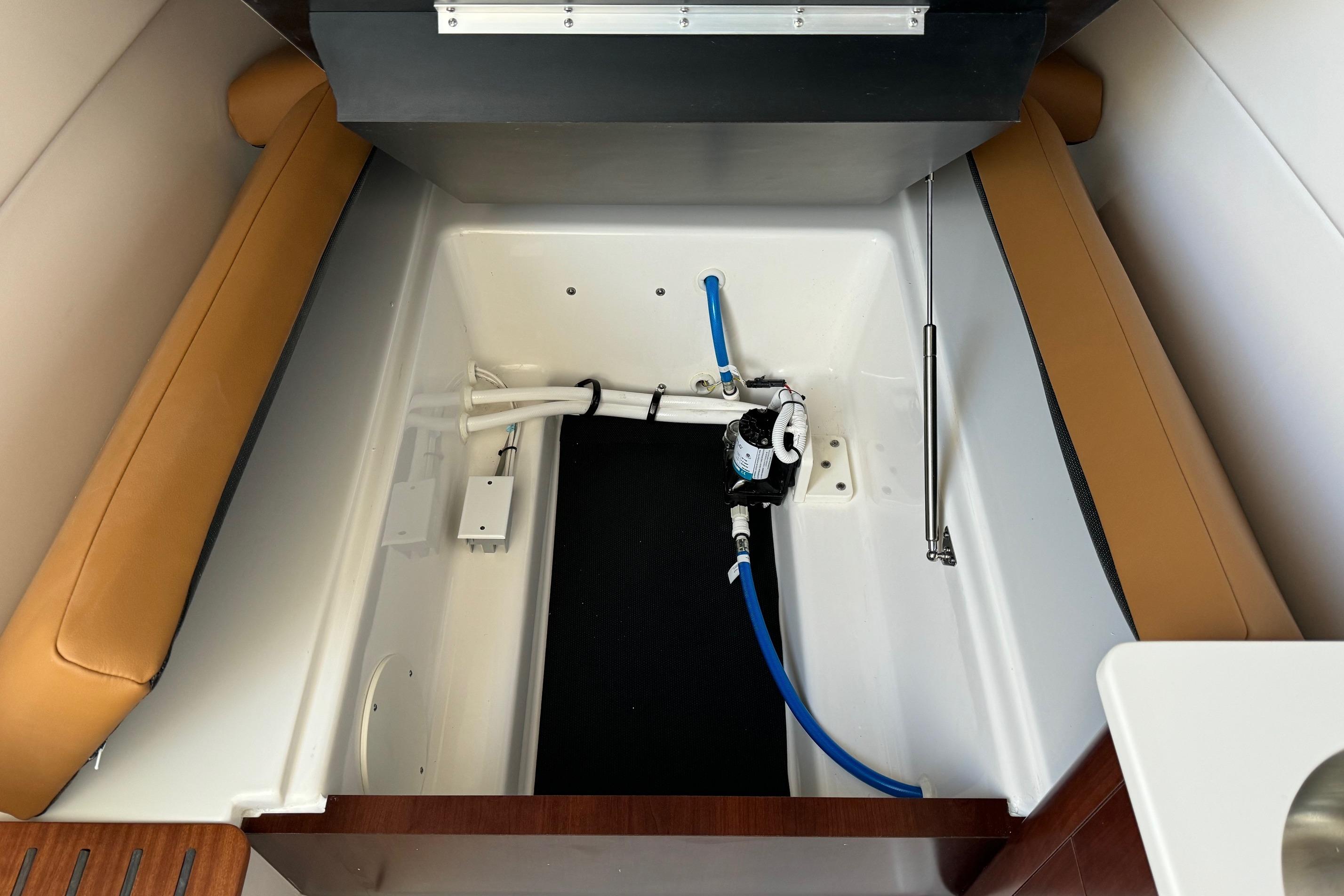 2025 Robalo R360 Center Console interior with storage compartment and plumbing system.