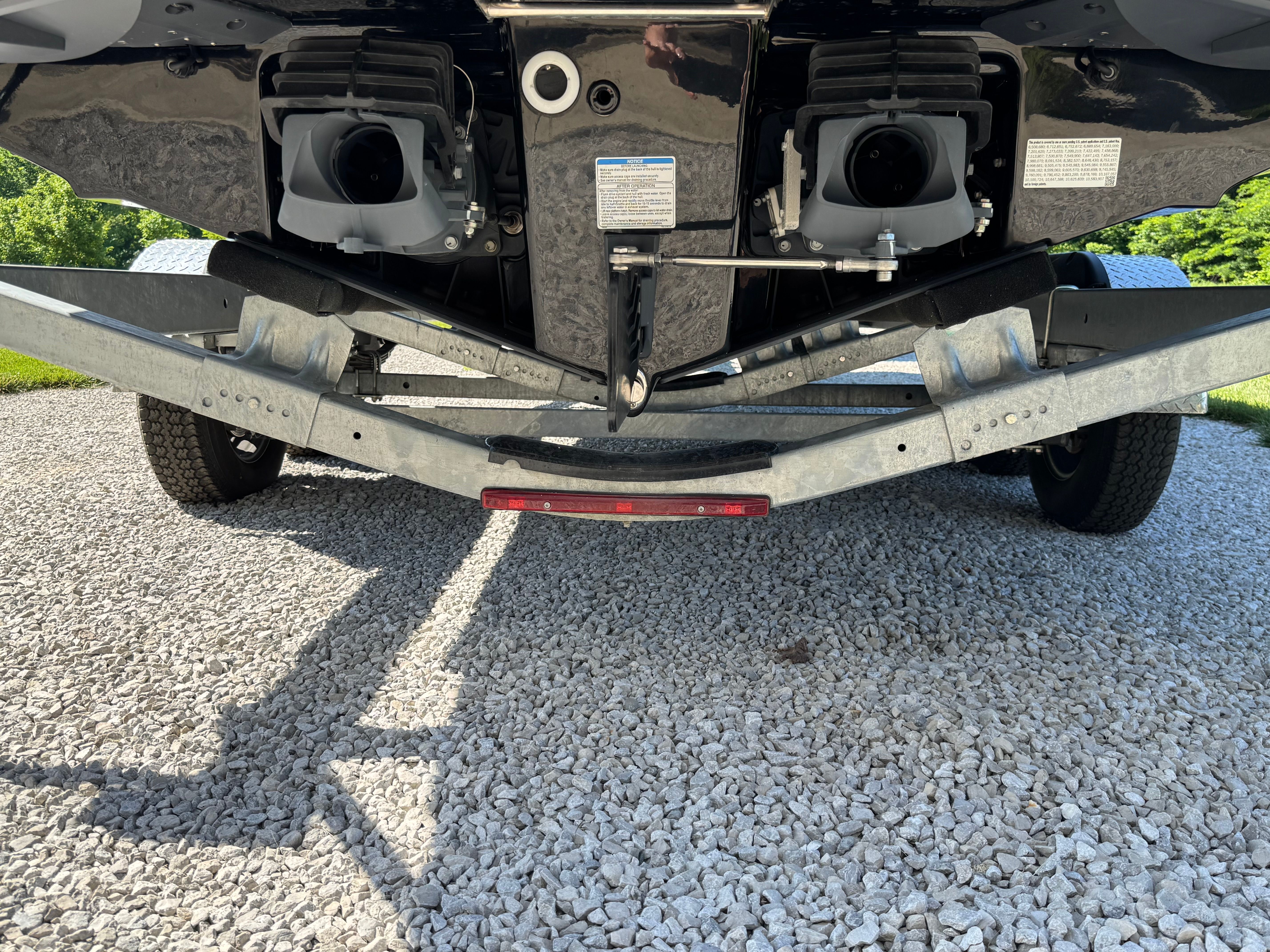 Underside of a Yamaha 255XD boat on a trailer, parked on gravel.