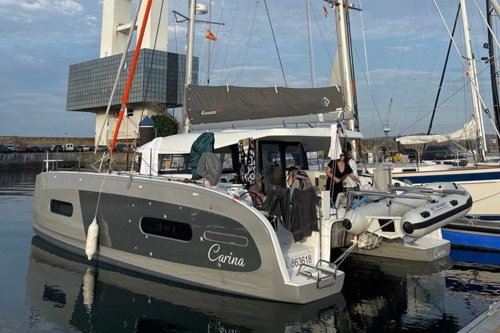 2023 Excess 11 catamaran "Carina" docked at marina with inflatable dinghy.