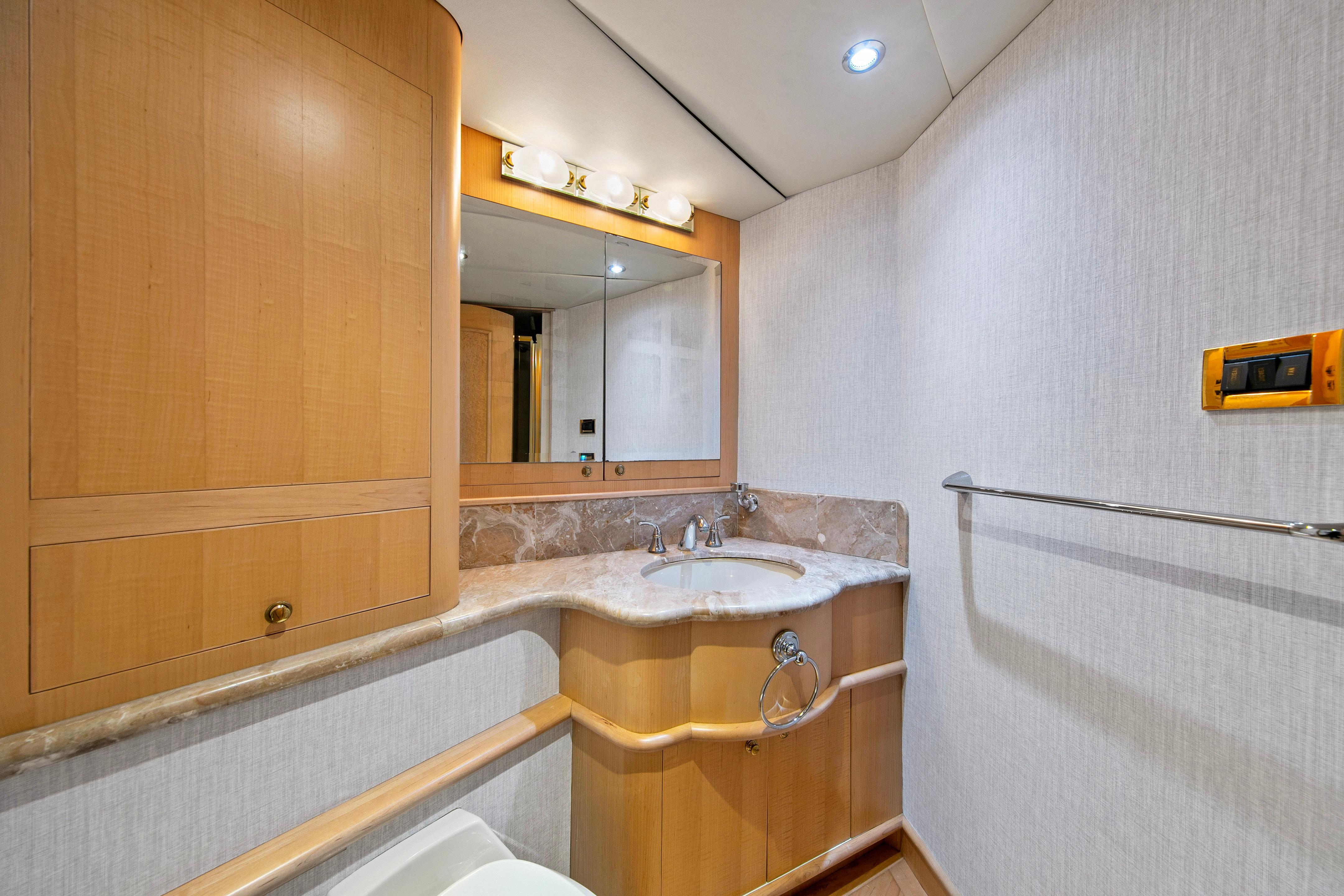 Luxurious bathroom in 1998 Westport Sovereign yacht with wood cabinetry and marble countertop.