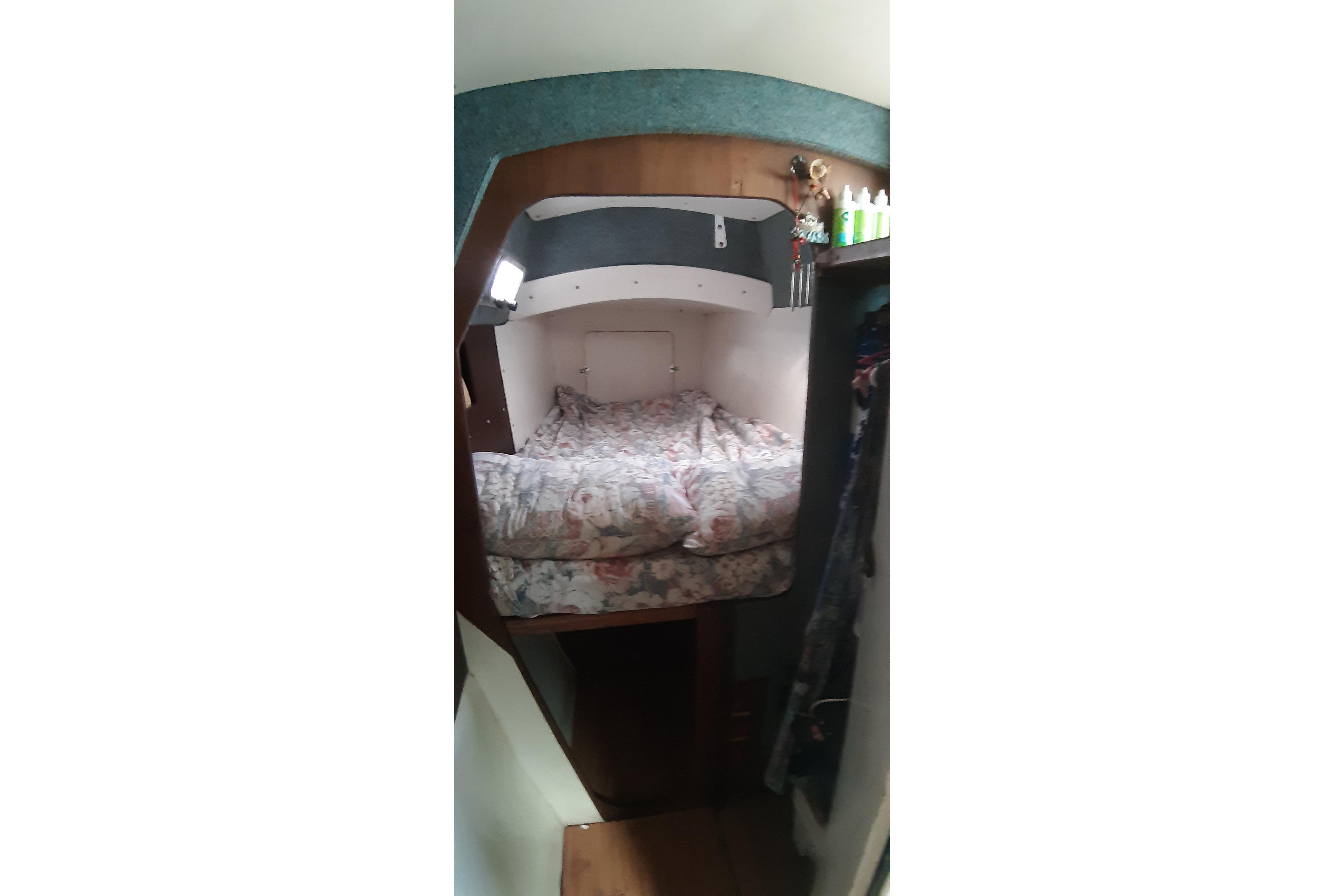 Cozy cabin interior of 1996 Caraibe 39 sailboat with floral bedding.