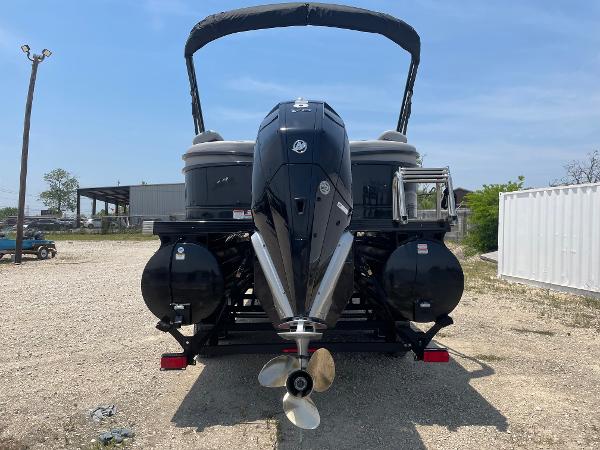 2023 Regency 250 LE3 pontoon boat with powerful outboard motor, parked on gravel.