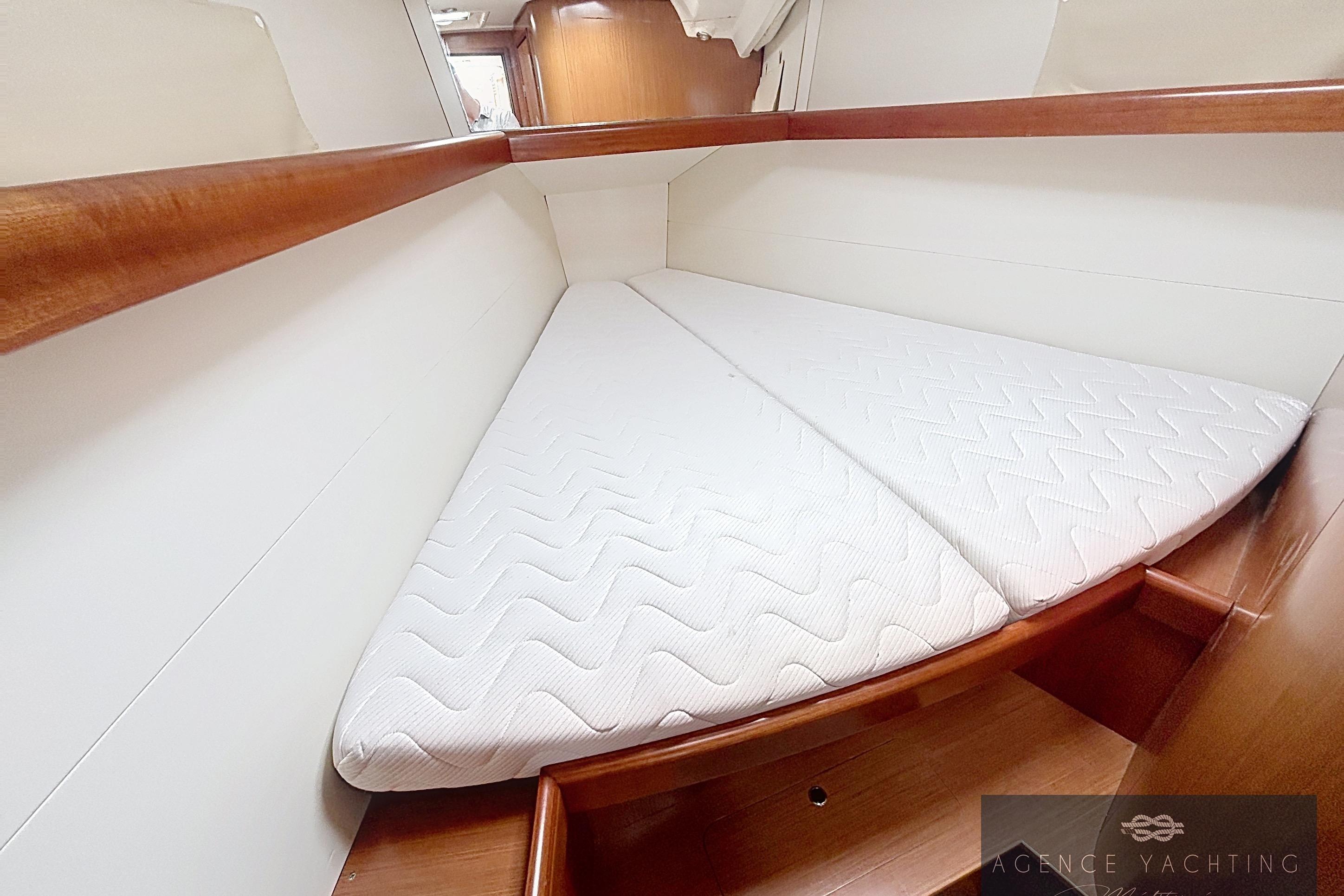 Interior cabin of 2008 Beneteau Oceanis 40 yacht with white mattress and wooden accents.