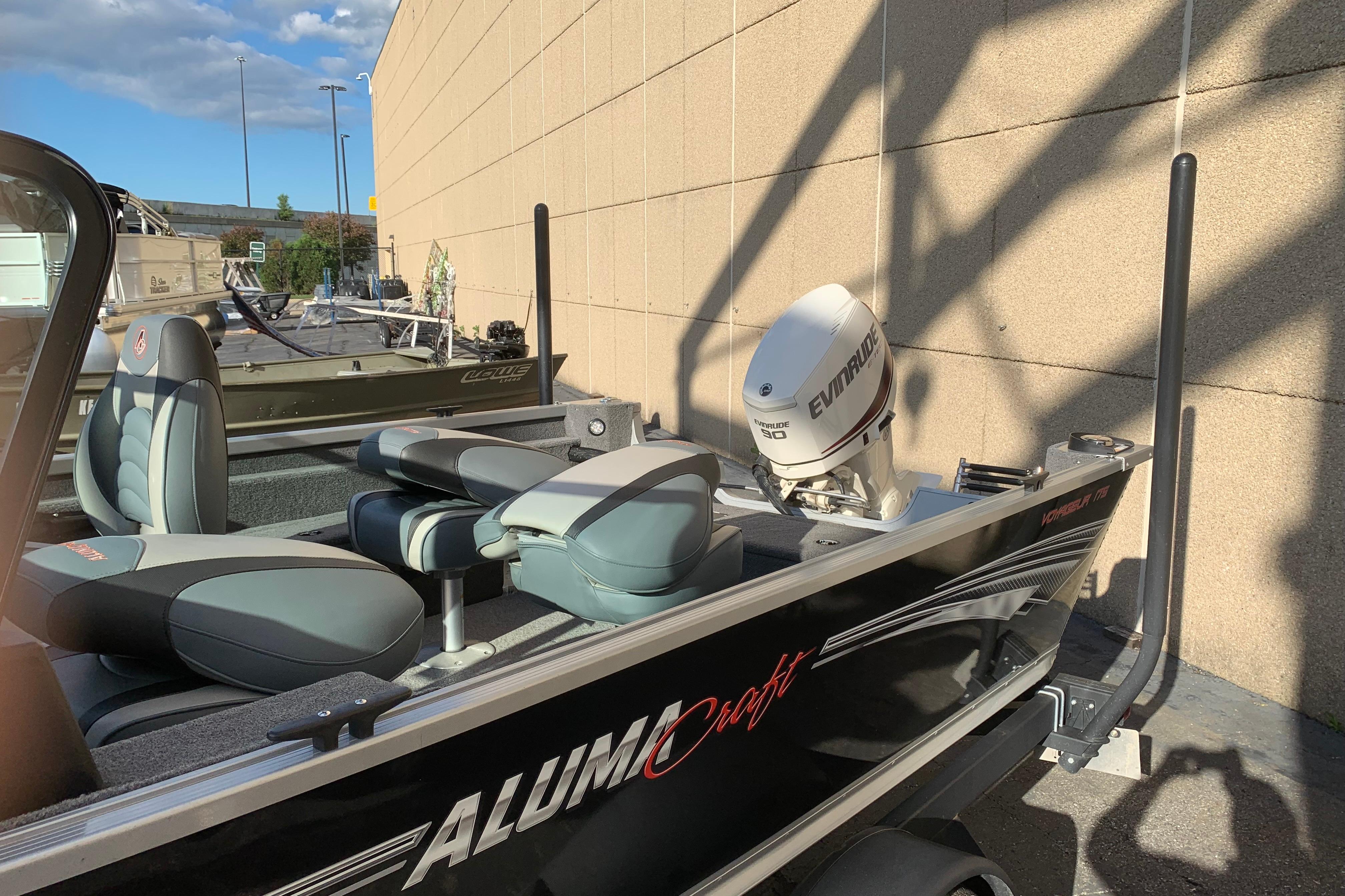 1993 Alumacraft Trophy 175 boat with Evinrude motor, parked outdoors in sunlight.