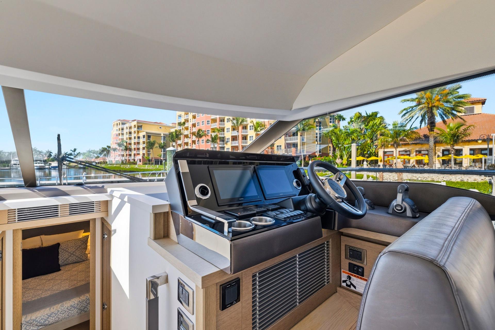 Luxurious 2022 Prestige 520 yacht interior with modern helm and waterfront view.