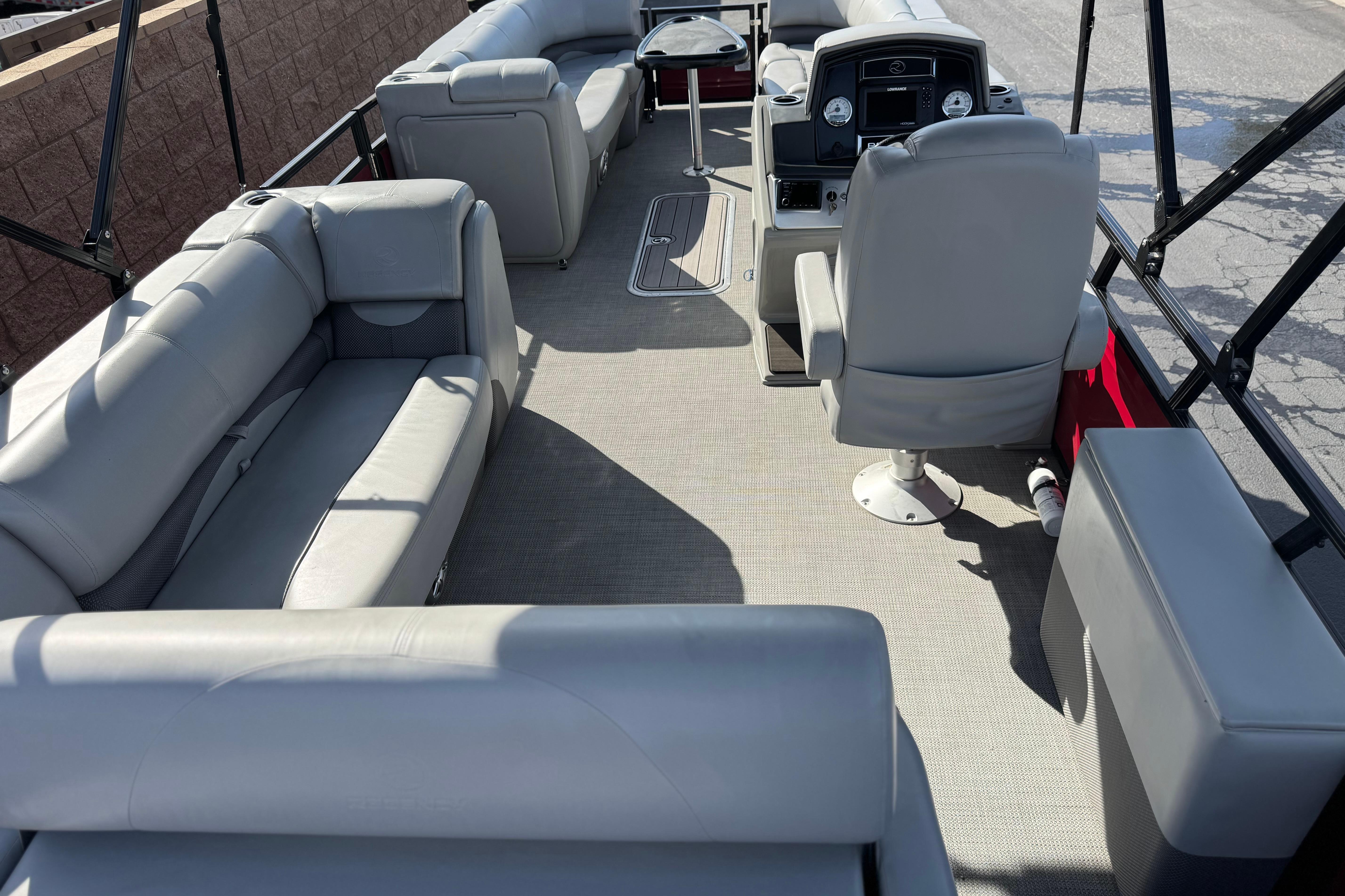 2023 Regency 250 DL3 pontoon boat interior with gray seating and helm.