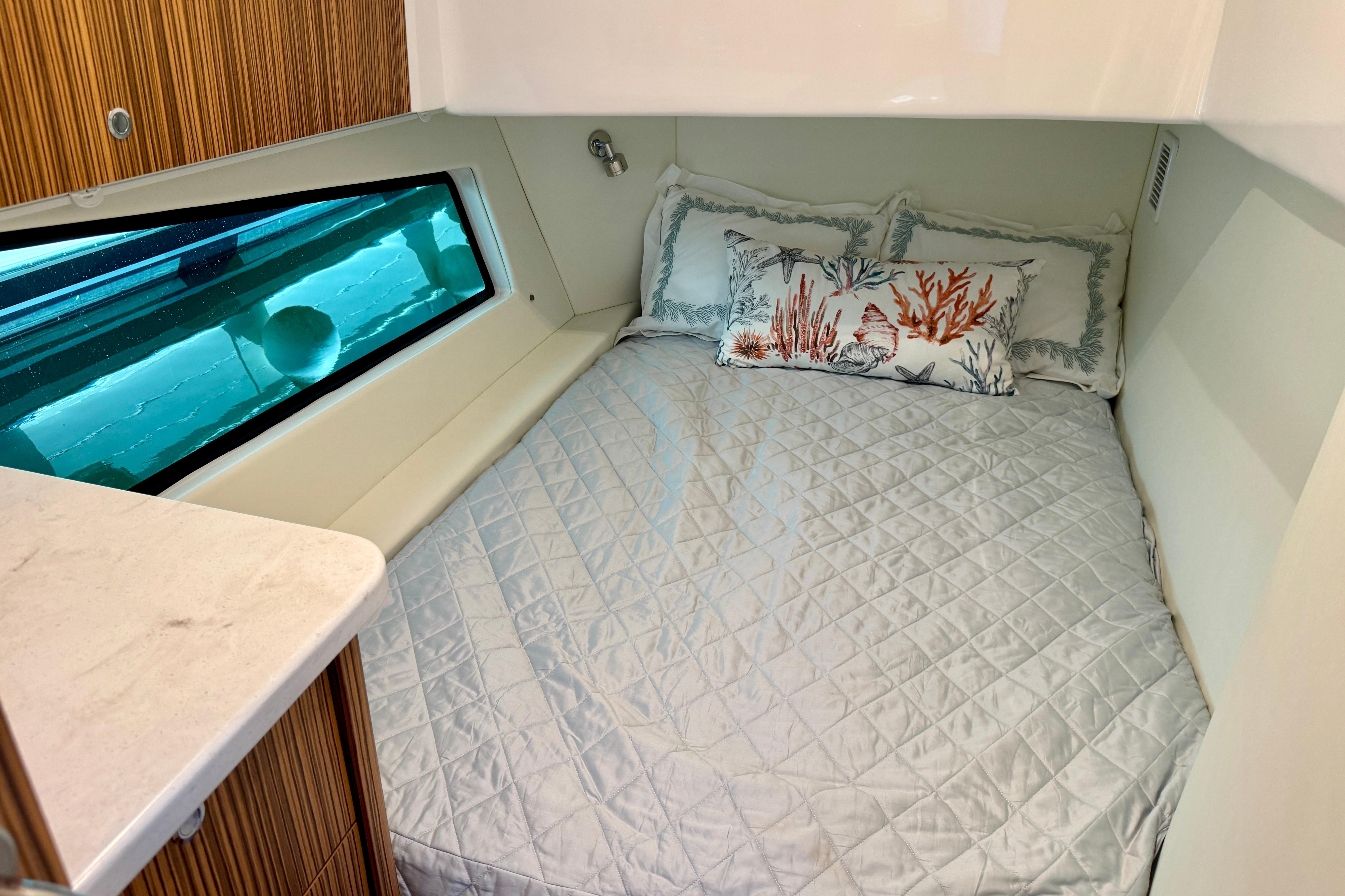 Cozy cabin interior of 2025 Intrepid 50 Evolution yacht with decorative pillows.