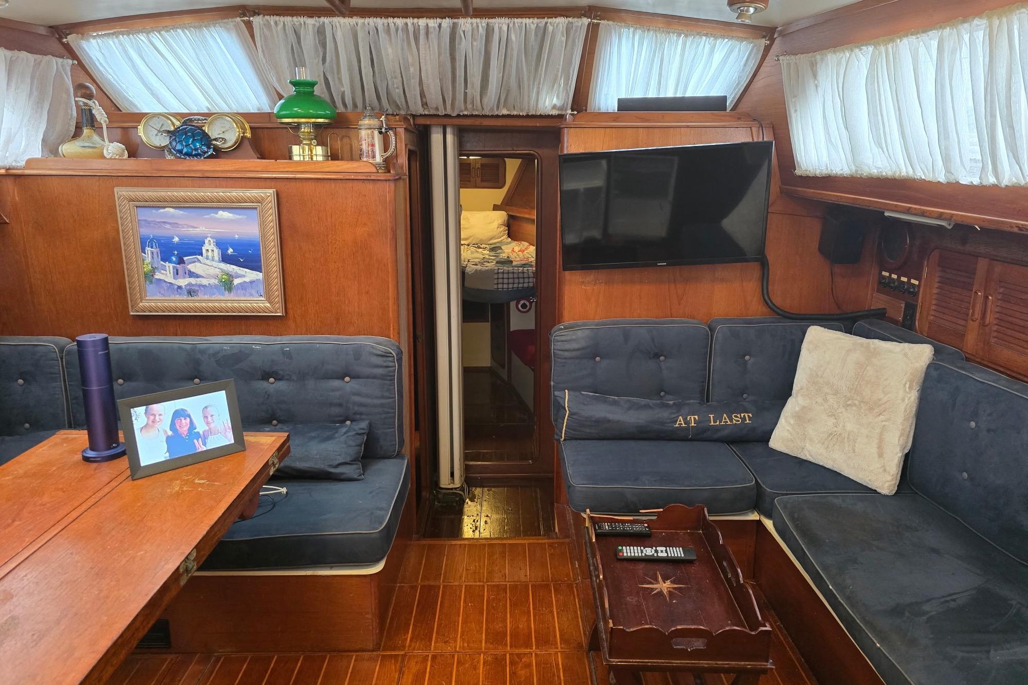 Interior of 1982 Irwin 52 yacht with cozy seating, decor, and wood paneling.