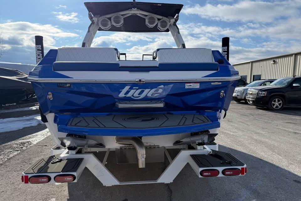 2026 Tigé Z3 boat, blue and white, parked outdoors under a clear sky.
