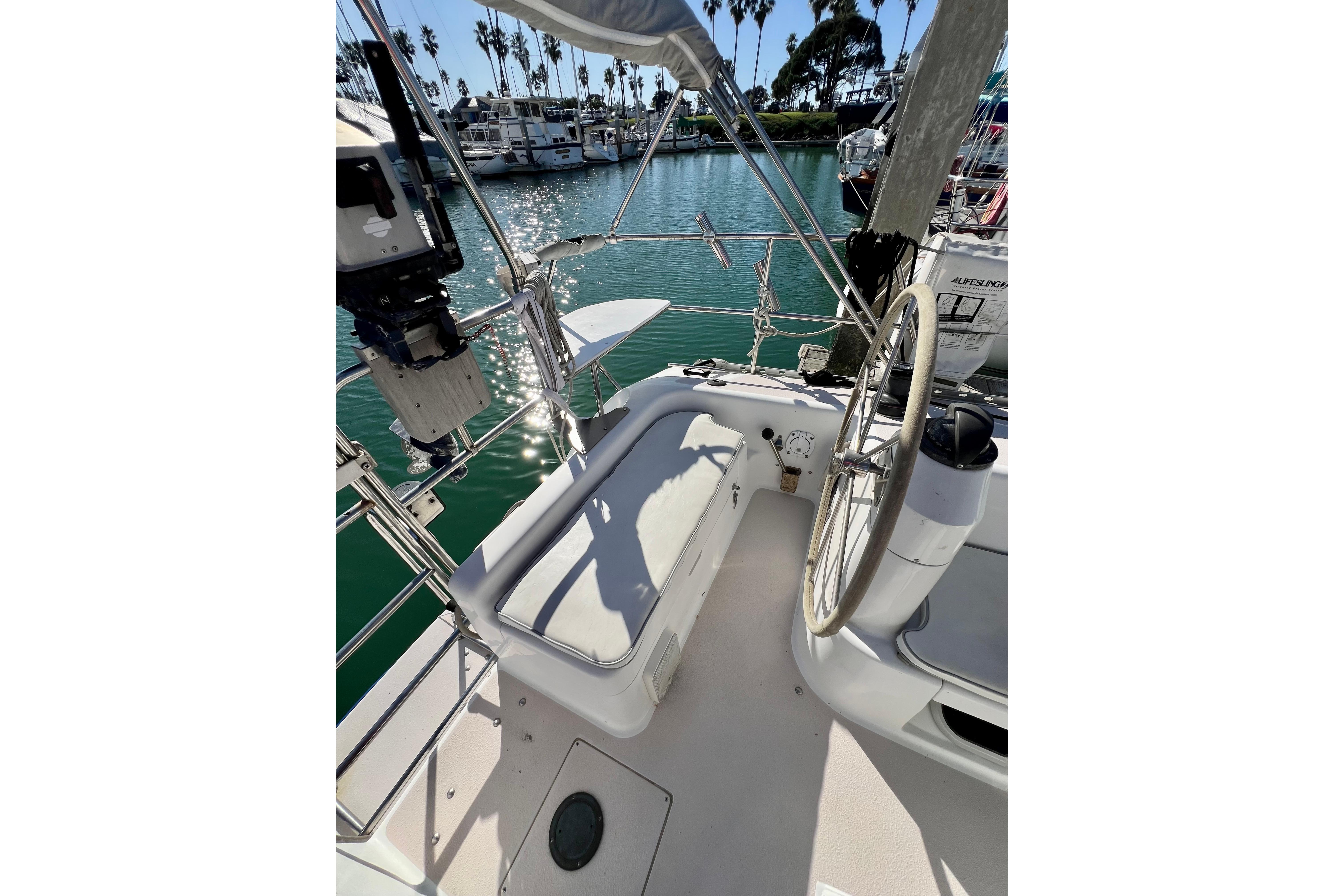 Cockpit of 1996 Catalina 400 sailboat with steering wheel and marina view.