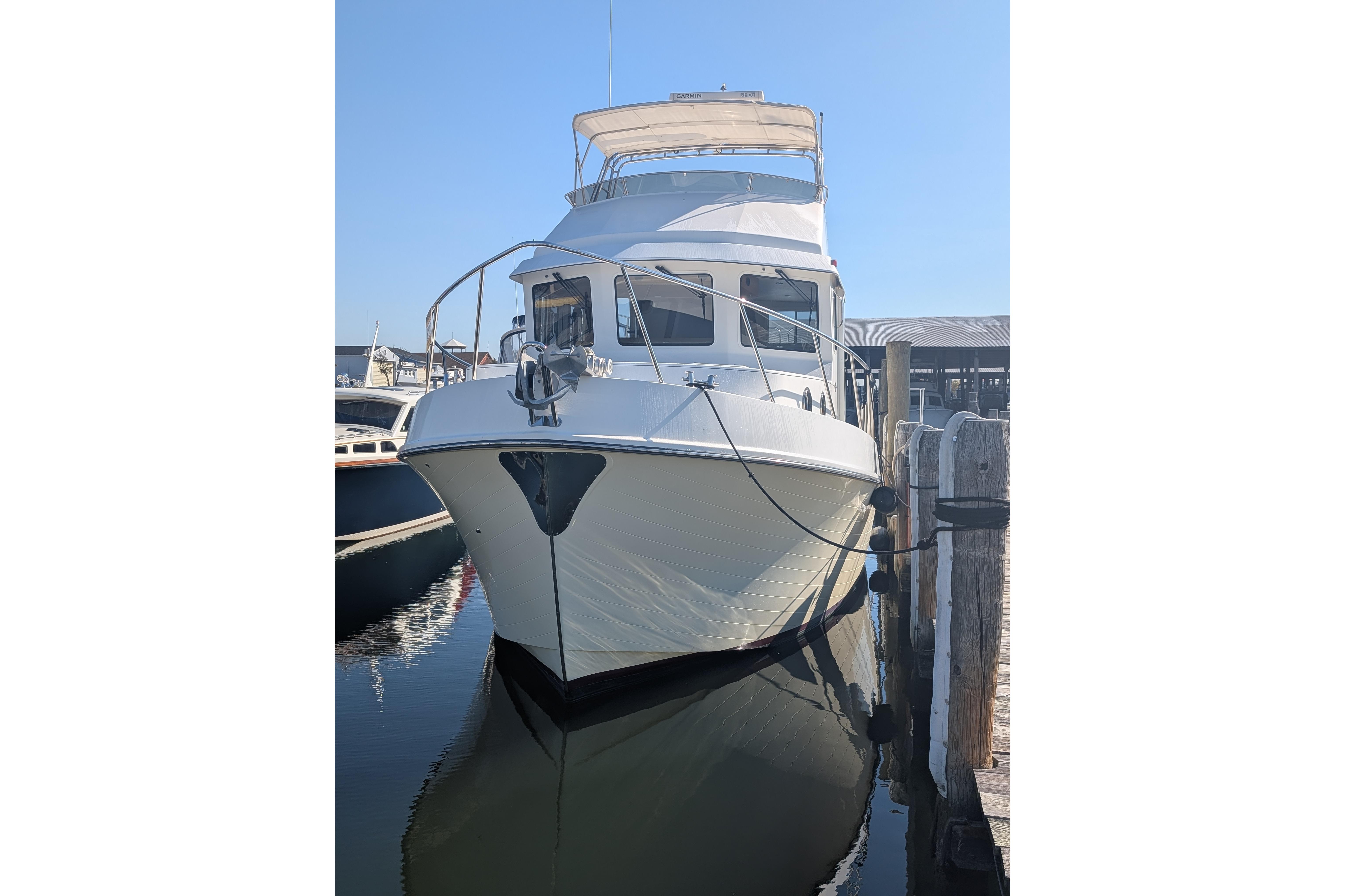 2015 American Tug 435 docked at marina, front view with clear blue sky.