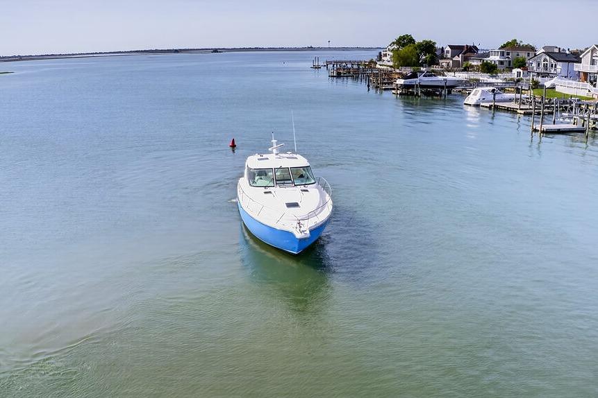 2006 Tiara Yachts 4300 Sovran cruising in a serene coastal waterway.
