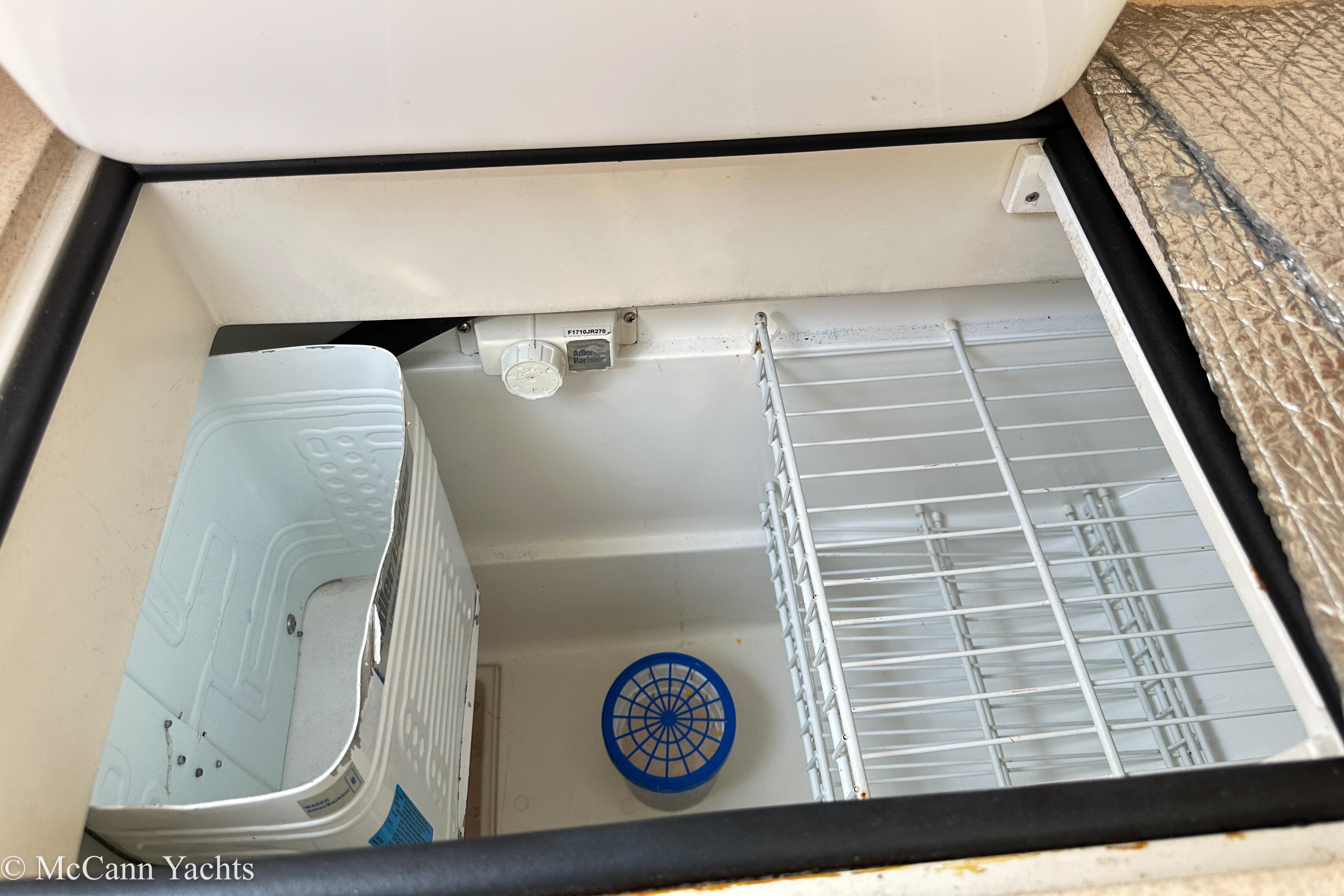 Interior view of a 2003 Catalina 320 yacht's storage compartment with wire shelving.