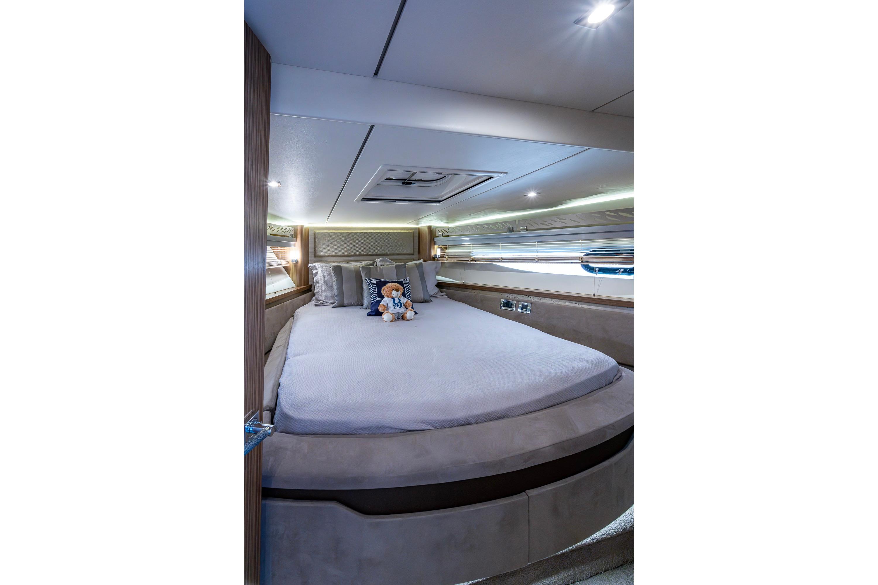 Luxurious bedroom interior of 2018 Sea Ray L550 Fly yacht with plush bedding.