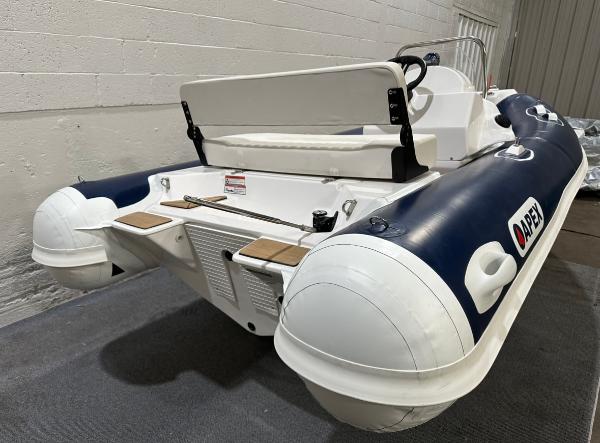 2024 Apex A-13 Deluxe Tender, inflatable boat with white and navy design, in indoor setting.