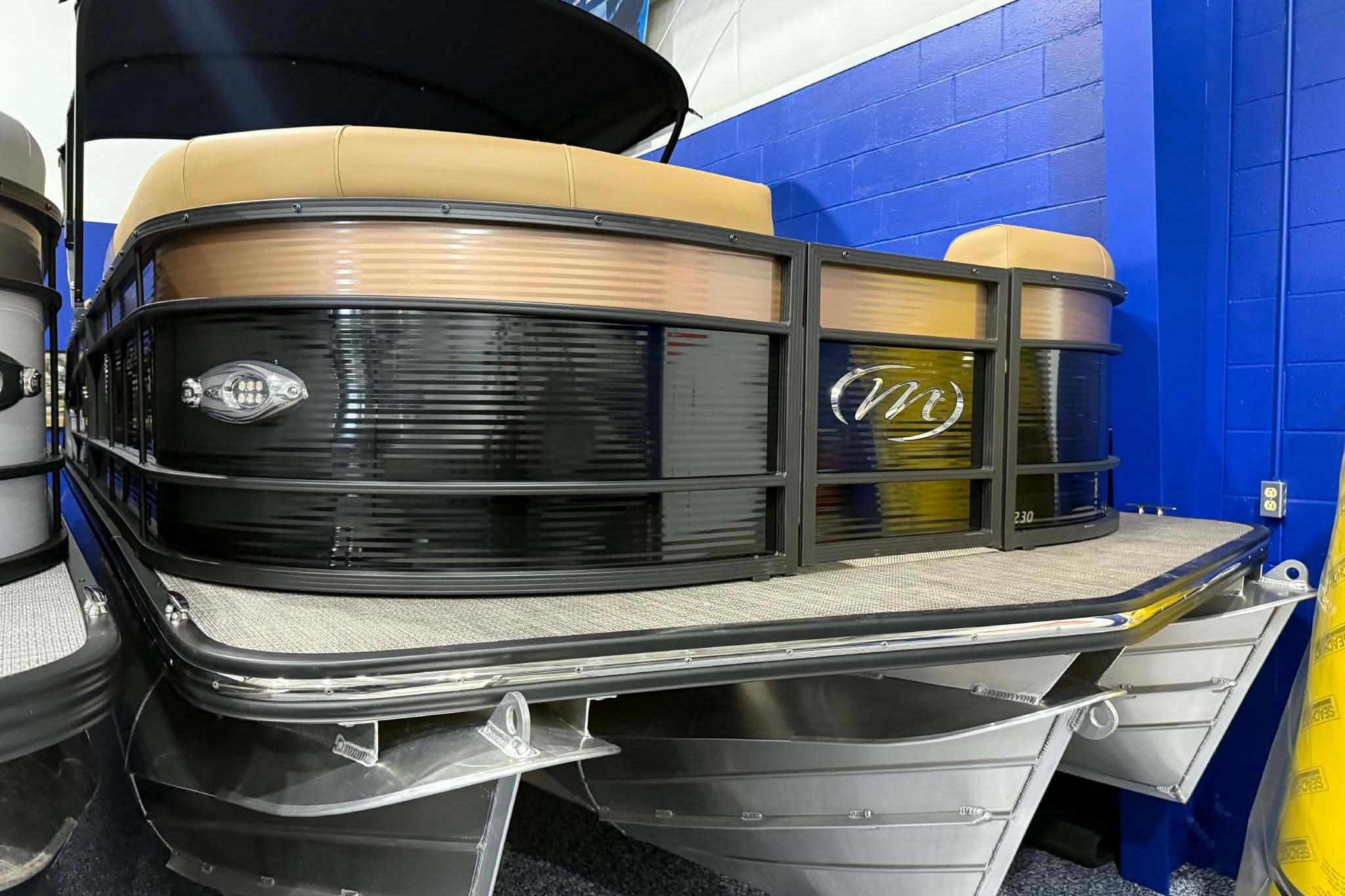 2026 Manitou Encore VP 230 pontoon boat with sleek black and tan design.