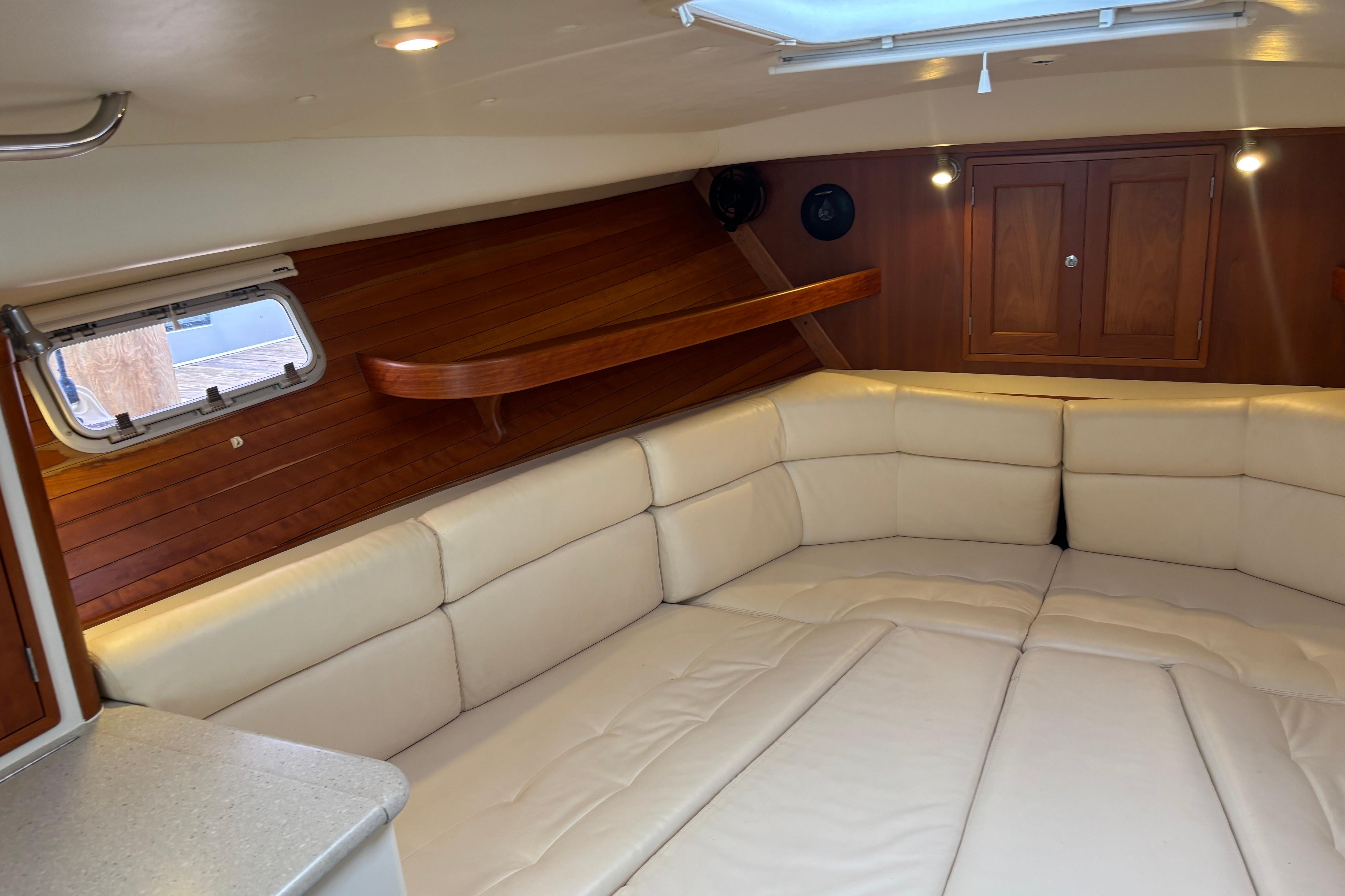 Luxurious interior of 2006 MJM 34z Downeast boat with cream seating and wood accents.