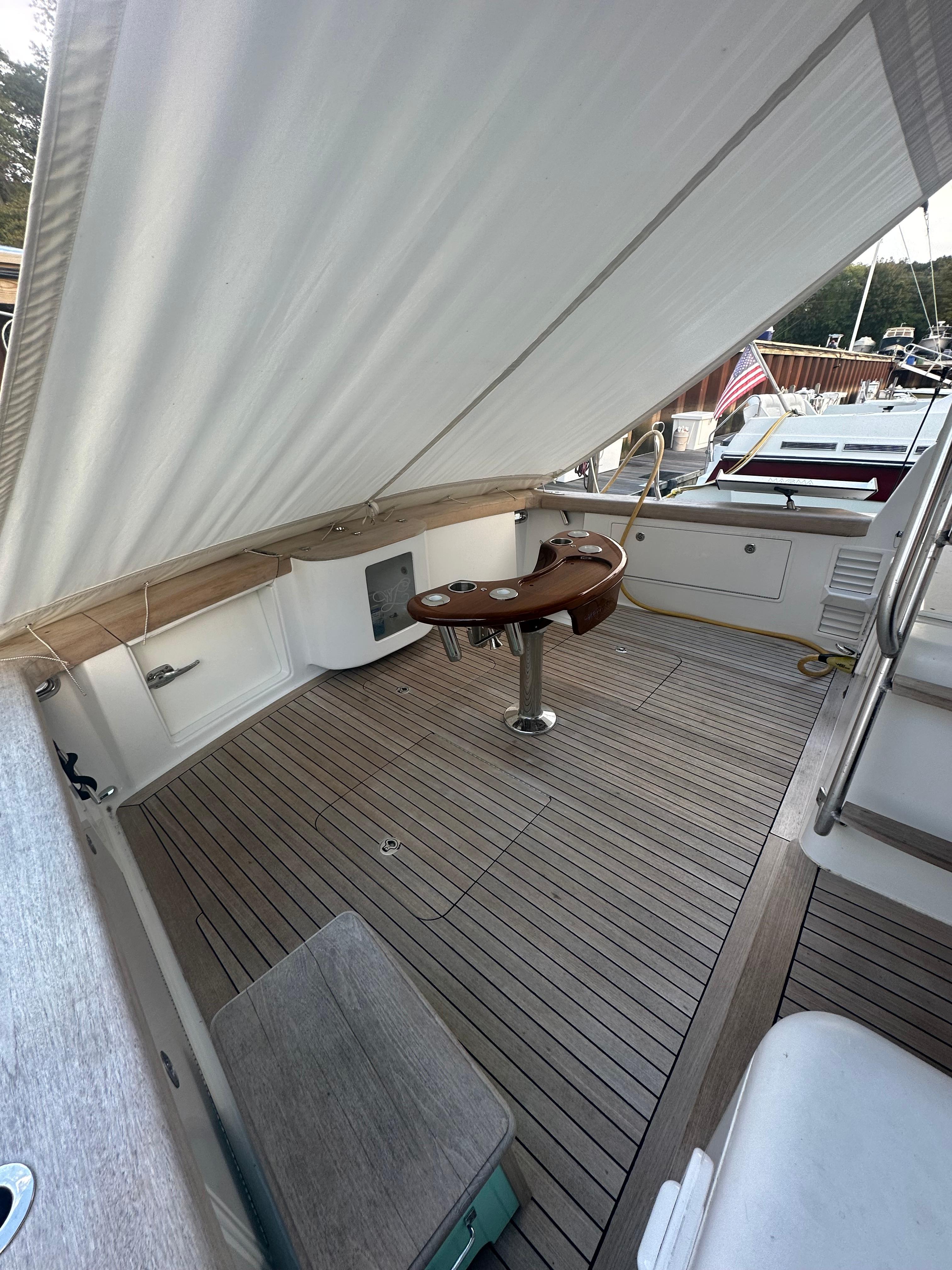 1993 Ocean Yachts 42 Flybridge deck with wooden flooring and fishing chair.