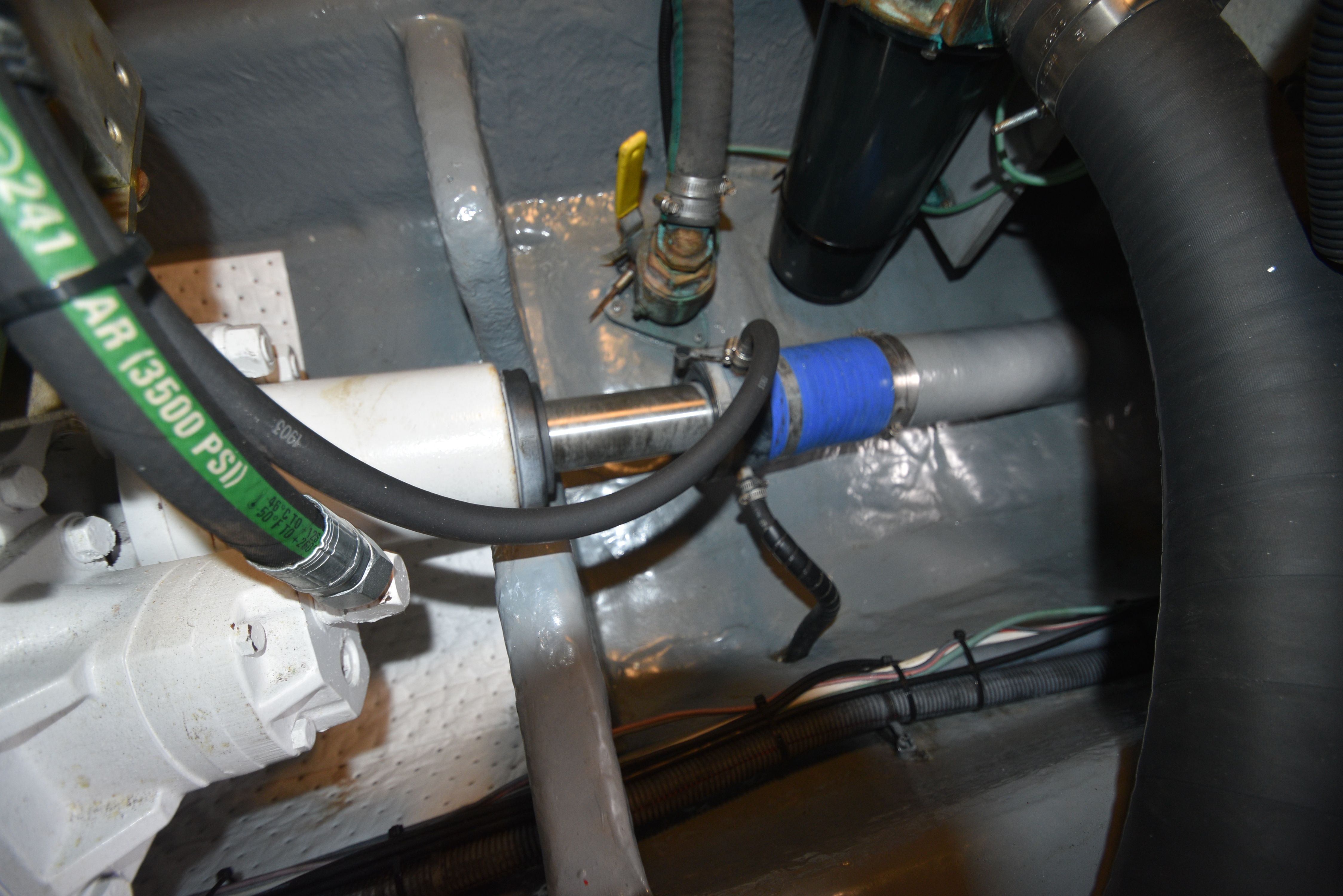 Close-up of a boat engine with hoses and metal components.