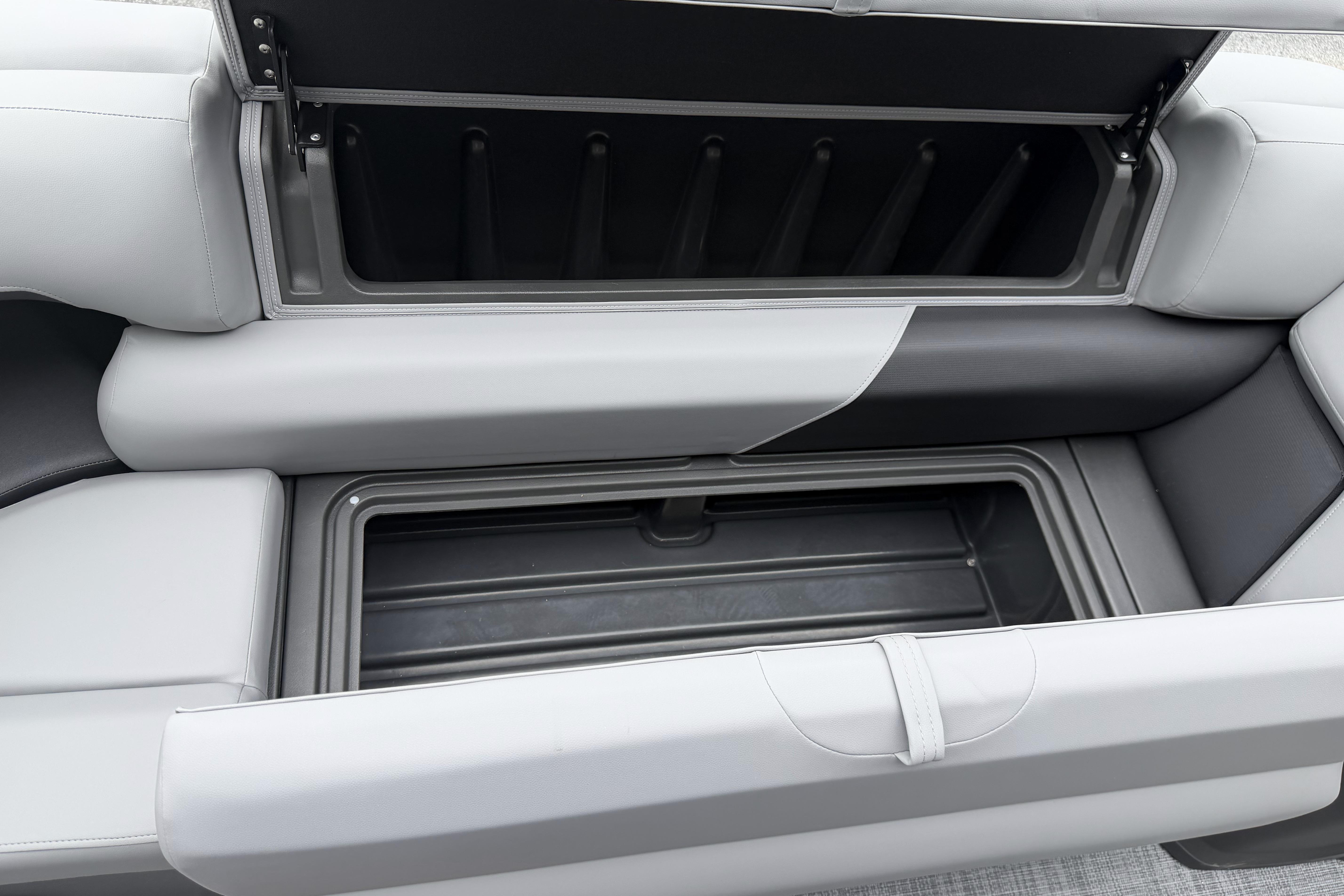 2026 Sun Tracker Party Barge 20 DLX storage compartment with open seat revealing interior space.